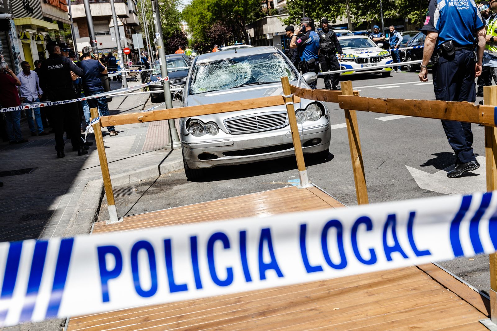 Agentes de la policía nacional custodian el coche con el que han sido atropelladas varias personas en el Paseo de Extremadura