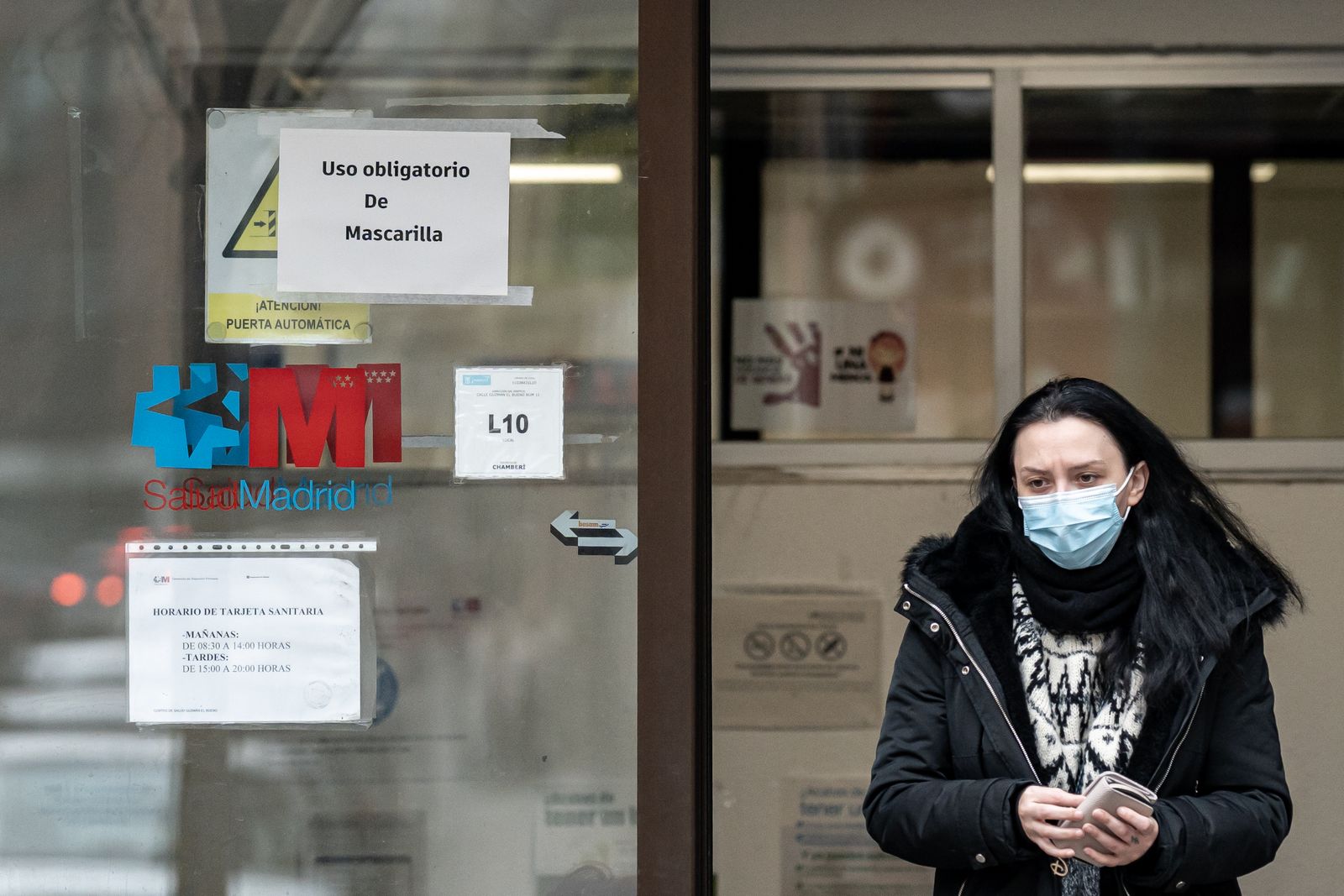 Una mujer sale con mascarilla del centro de salud de Guzmán El Bueno