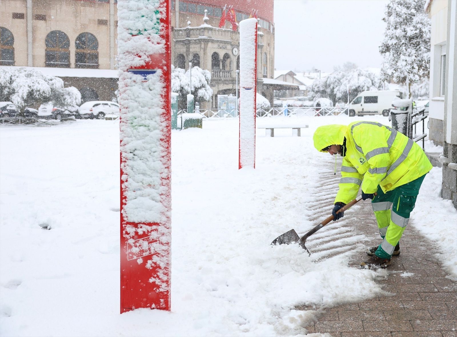 Un trabajador retira la nieve de una parada de autobús