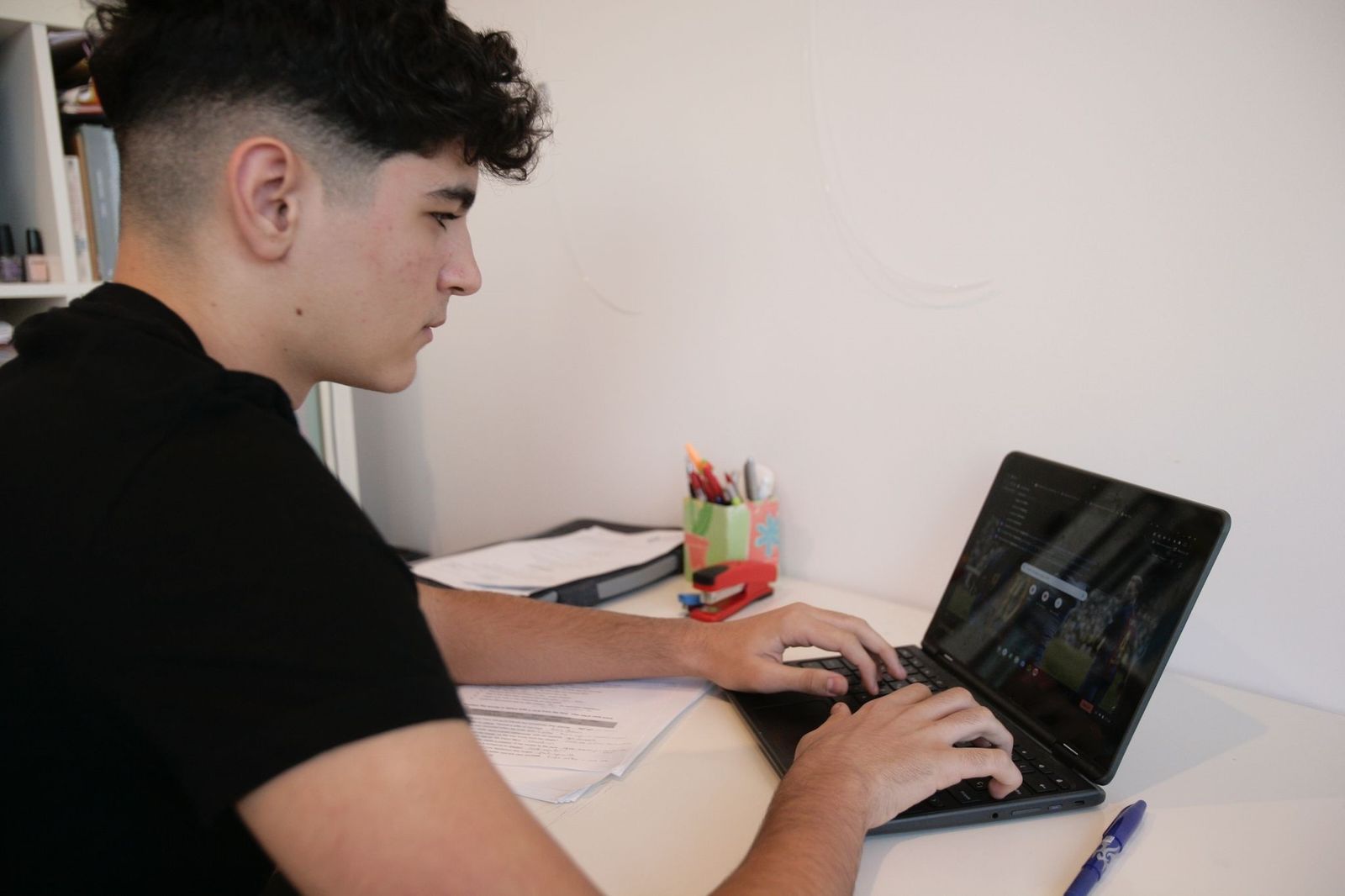 Un joven delante de su ordenador portátil