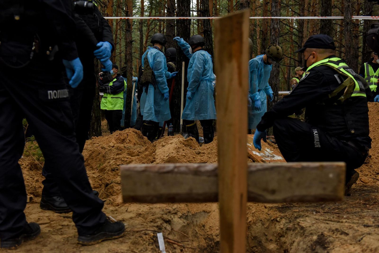 Levantamiento de cuerpos hallados en una fosa común en Izium