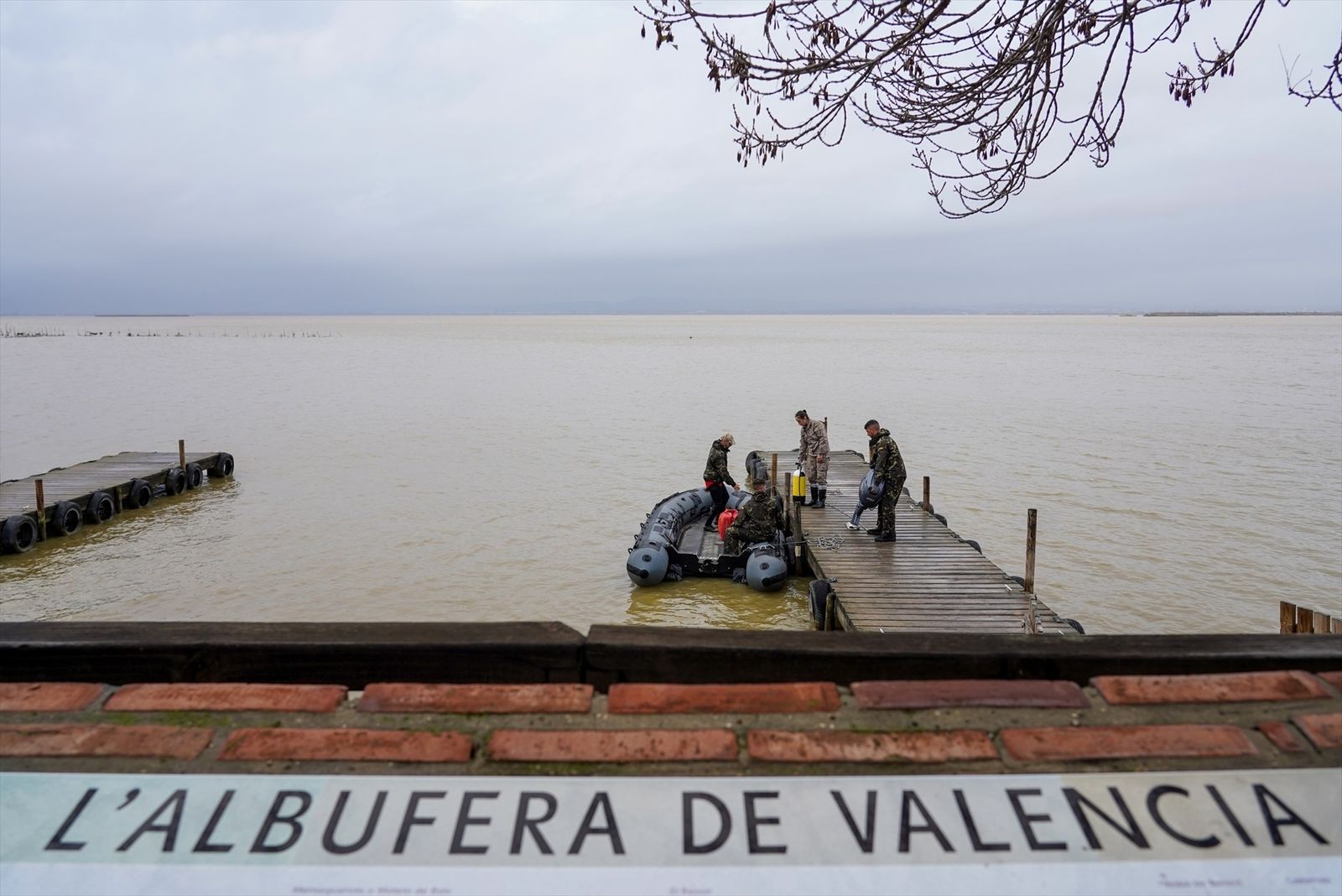Varios militares de la Armada preparan una lancha para el trabajo de búsqueda en La Albufera