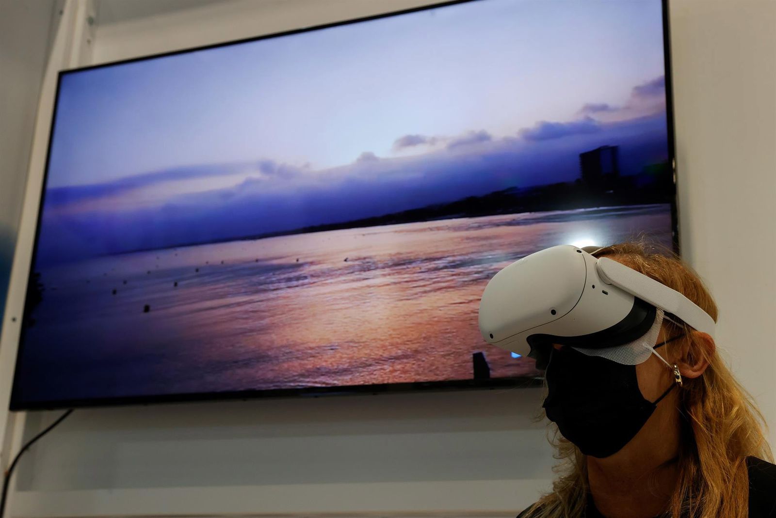 Un visitante utiliza un dispositivo de realidad virtual mientras visita uno de los estands durante la jornada inaugural de Fitur 2022