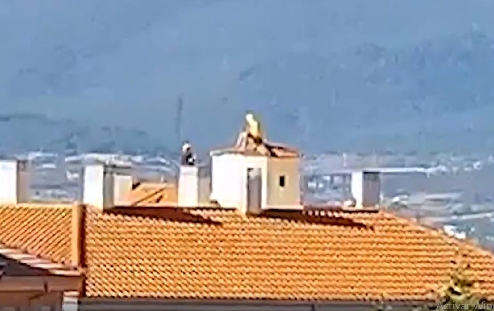 Uno de los agentes trata de convencer al joven para que baje del tejado