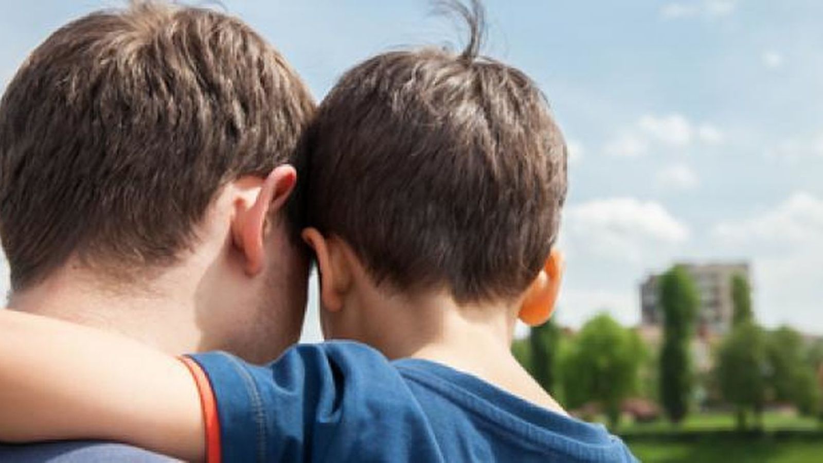 Un menor en brazos de su padre