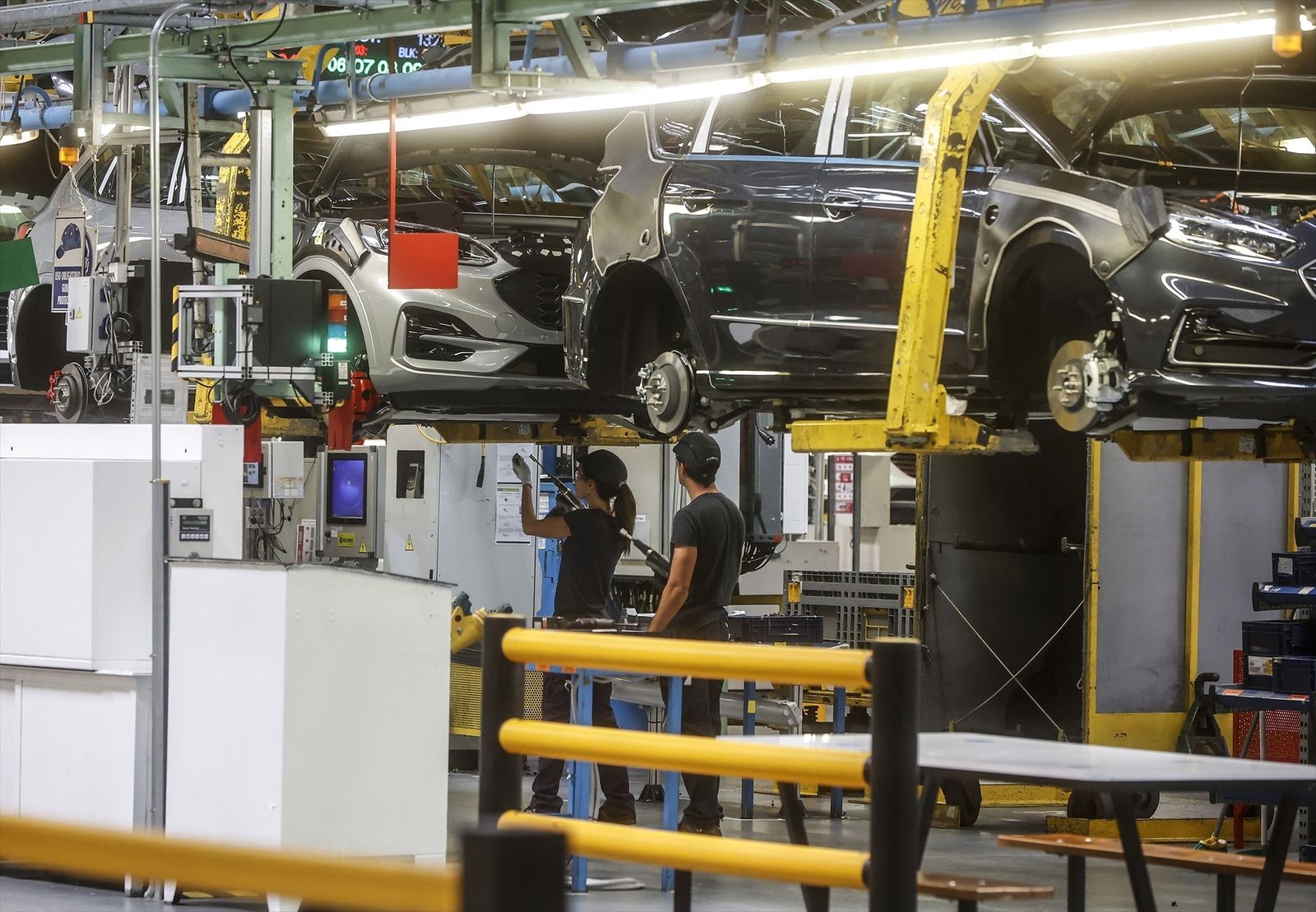 Dos trabajadores con un vehículo en la fábrica de Ford en Almussafes