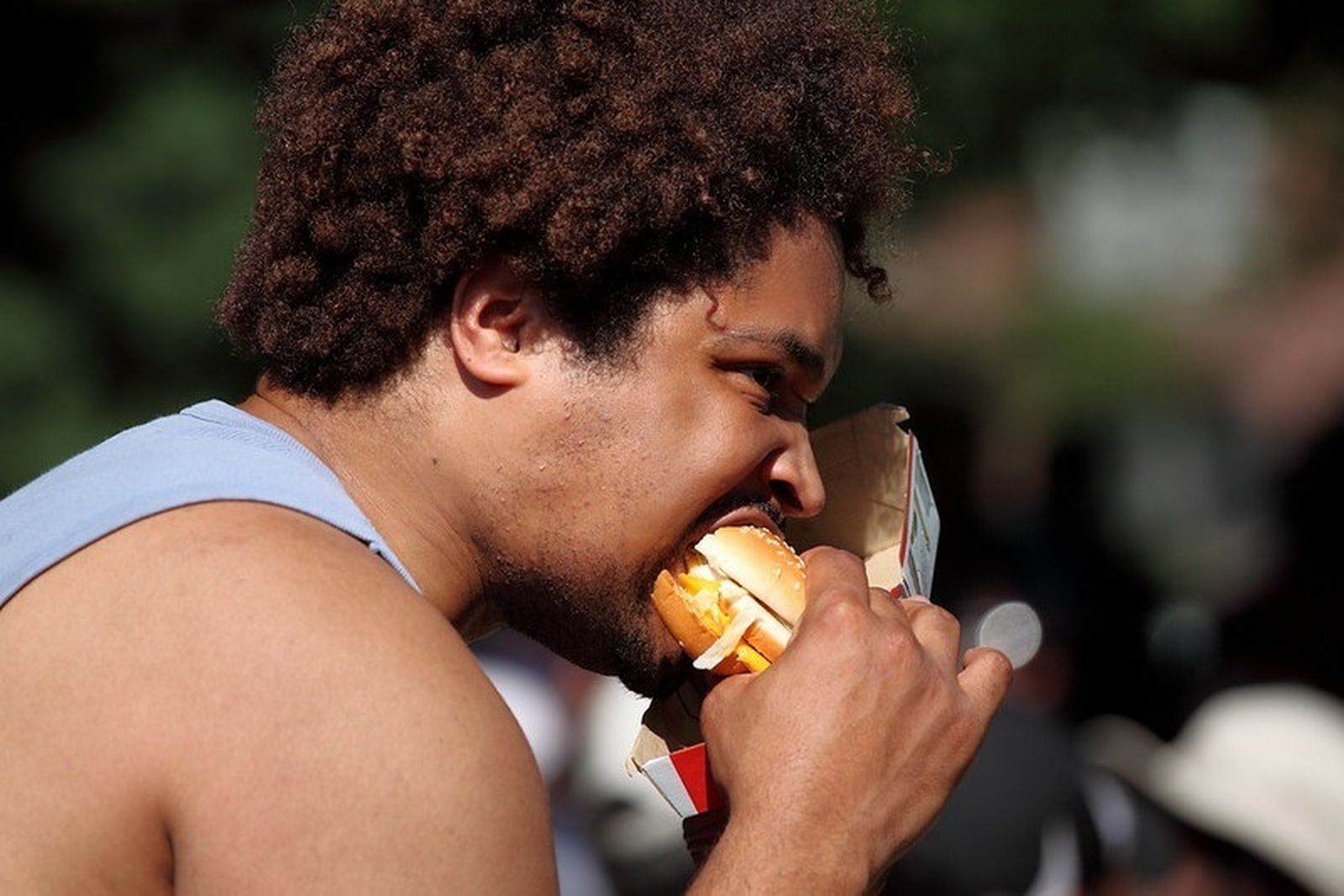 Hombre comiendo una hamburguesa