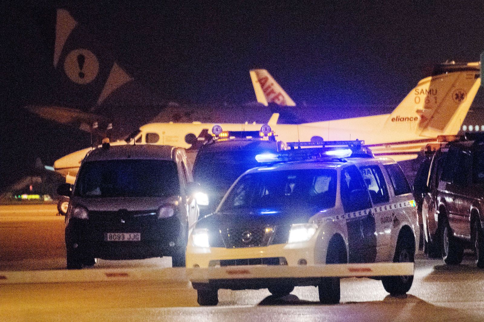 Miembros de la Guardia Civil y de seguridad del aeropuerto de Palma de Mallorca buscan por las pistas y sus aledaños a un grupo de pasajeros que ha obligado a cerrar la instalación.