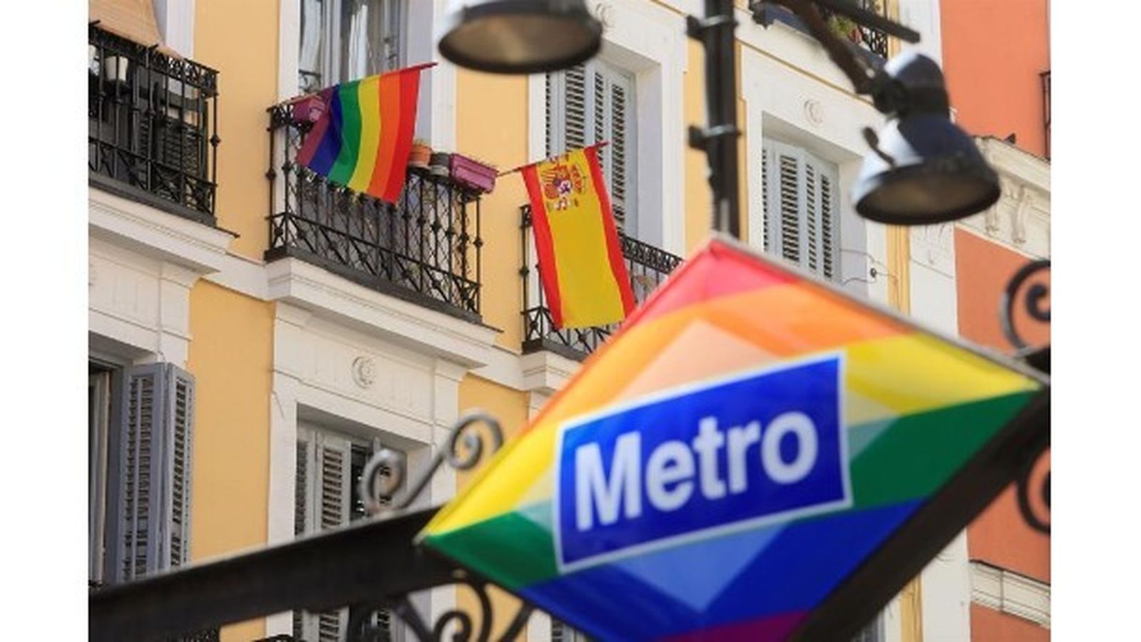 Banderas arcoíris y española decoran un balcón de la madrileña plaza de Chueca