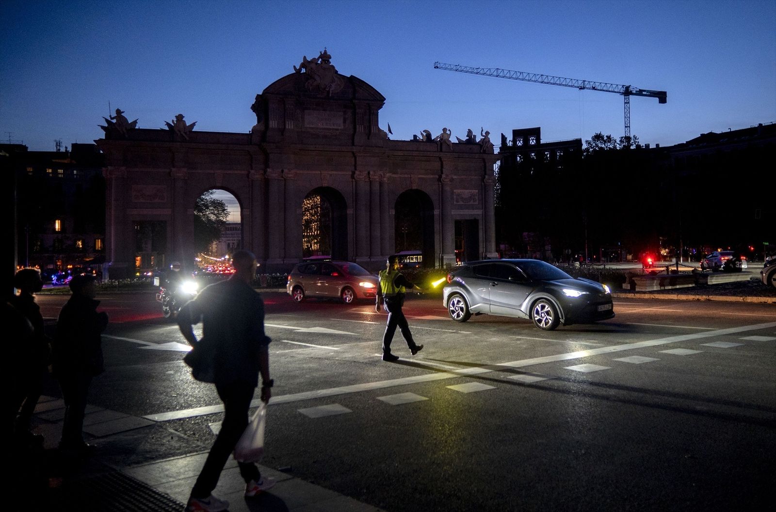 Un agente de Policía Municipal dirige el tráfico en la Puerta de Alcalá tras el apagón eléctrico