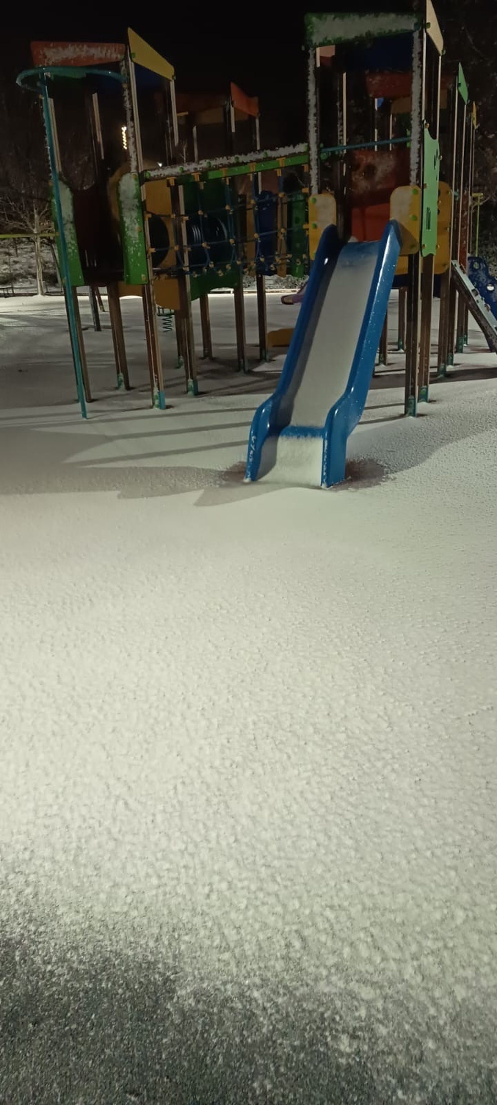 Parque de niños cubierto de nieve en Cobeña