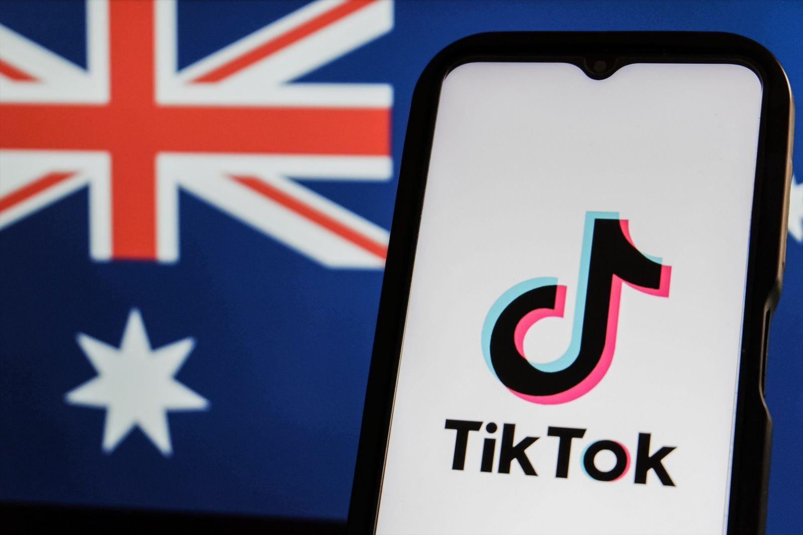 El logotipo de TikTok en la pantalla de un teléfono con la bandera australiana de fondo