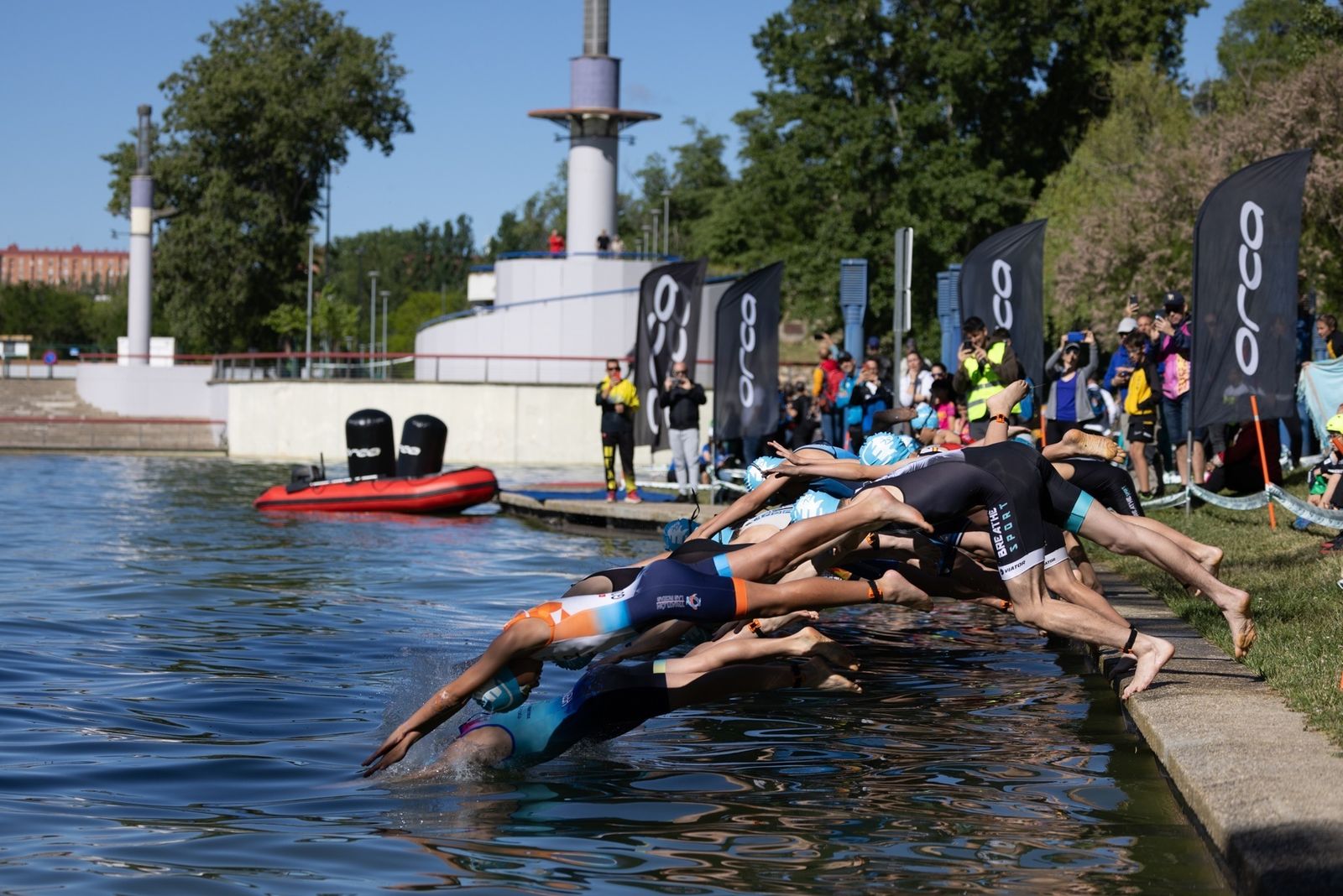 Deportistas se lanzan al Lago del Parque Central durante la celebración del Triatlón de Tres Cantos