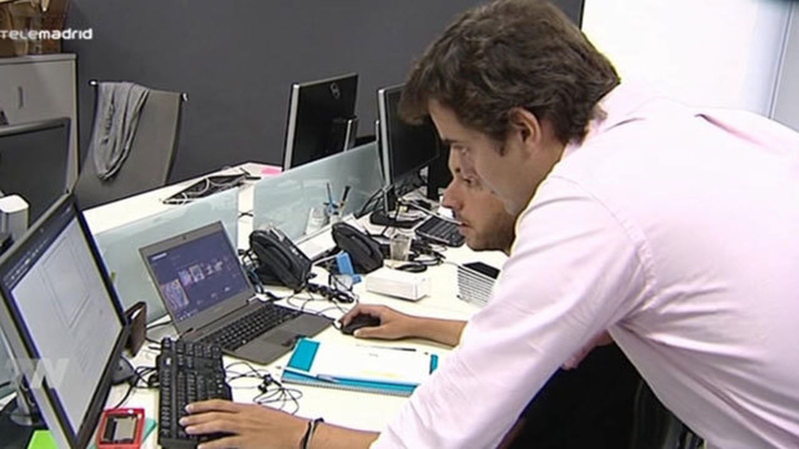Trabajadores delante de varios equipos informáticos
