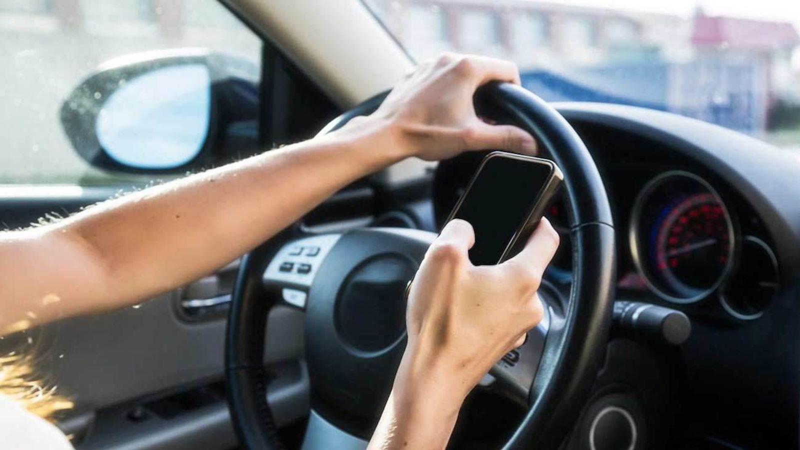 Un conductor usando el móvil al volante