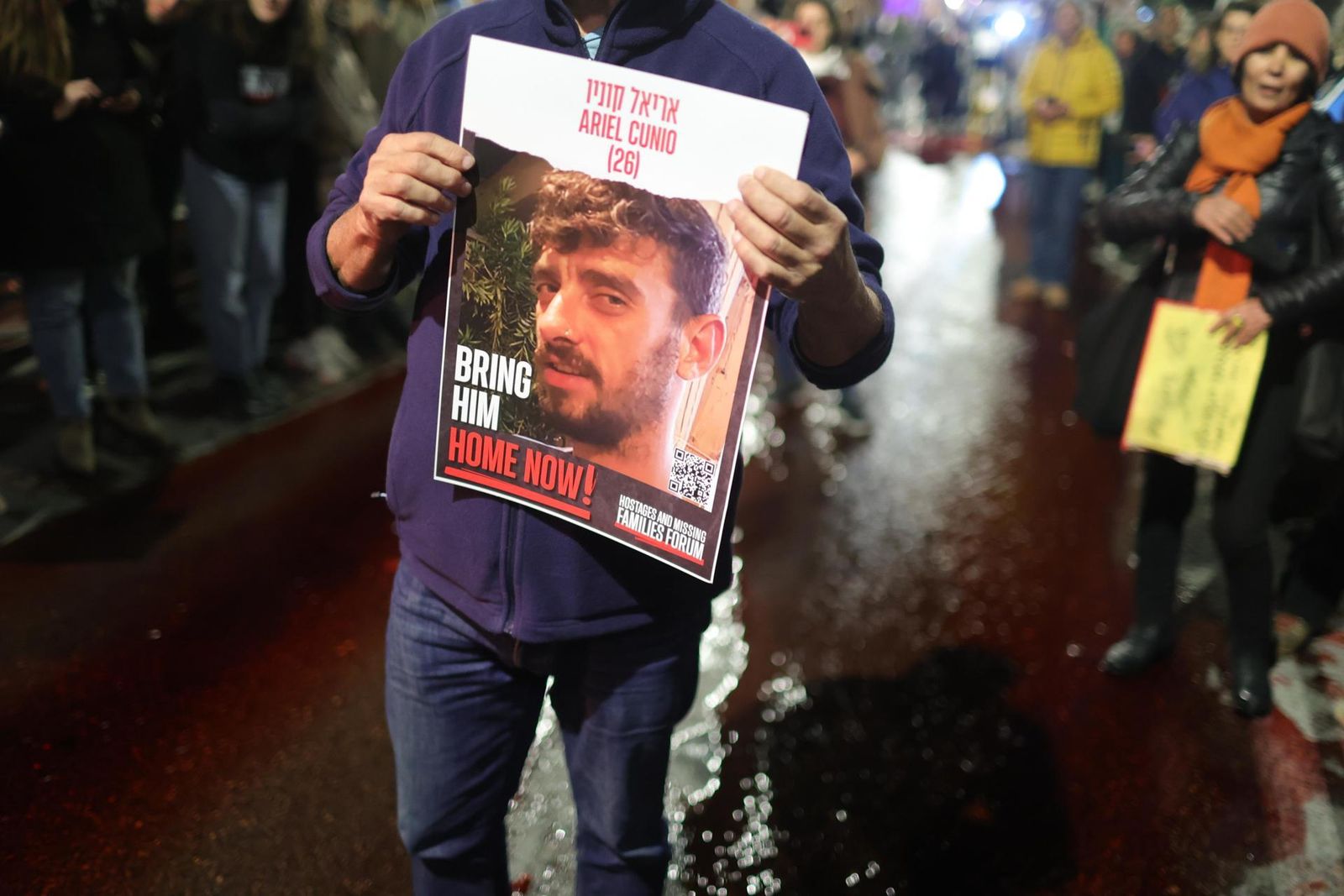 UN hombre sostiene la foto de uno de los rehenes israelíes en manos de Hamás
