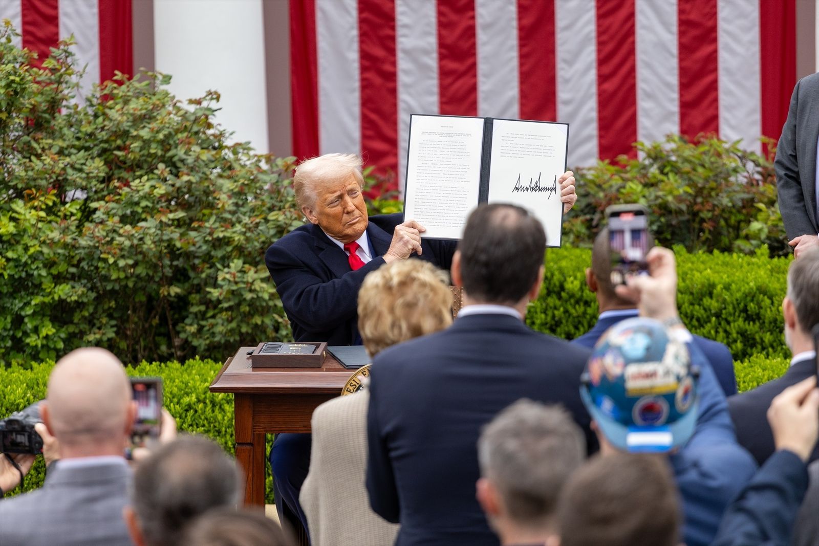Donald Trump exhibe un documento firmado por él ante la Casa Blanca