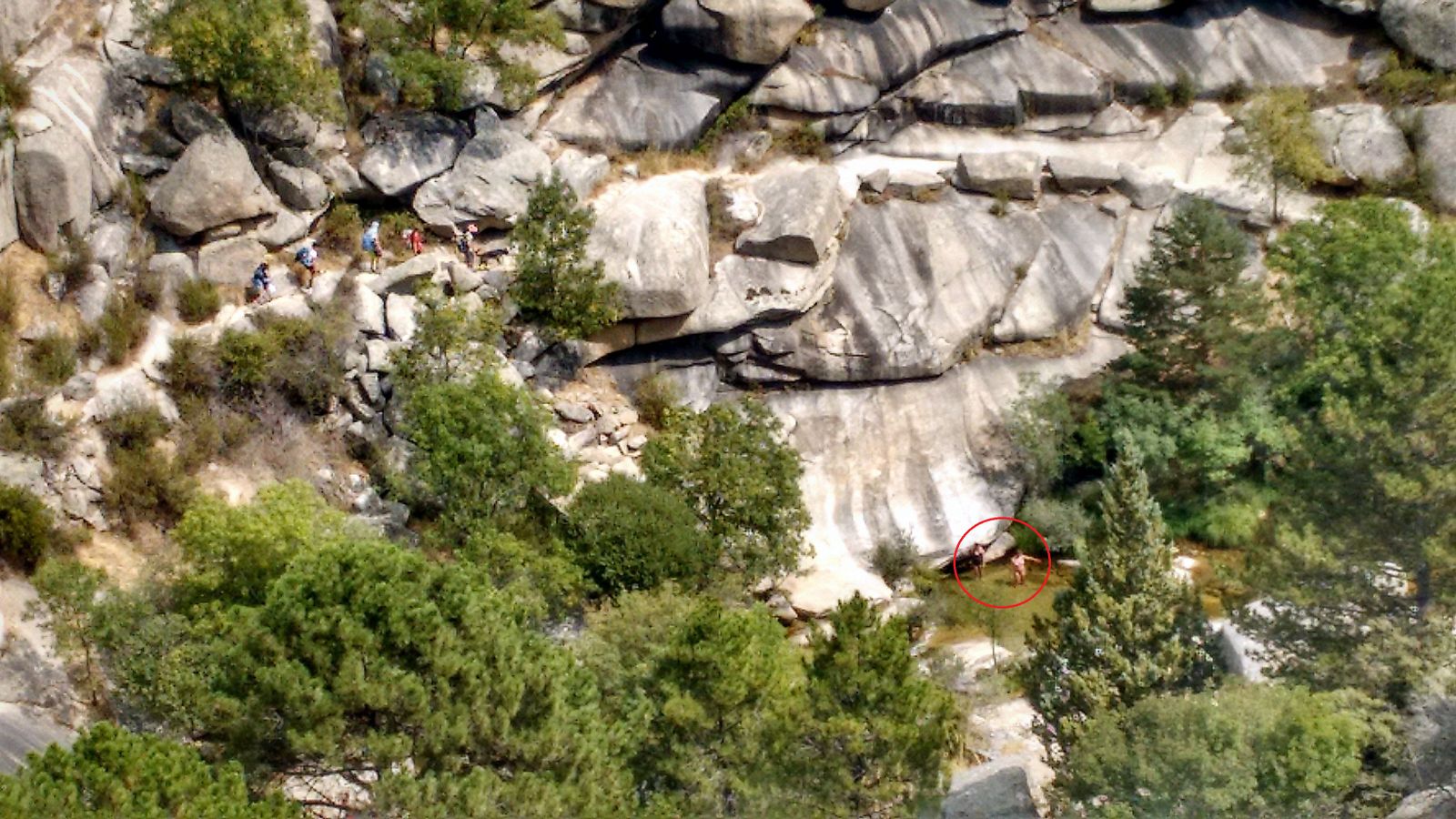Personas en el río Manzanares a su paso por La Pedriza, a pesar de la prohibición de baño existente