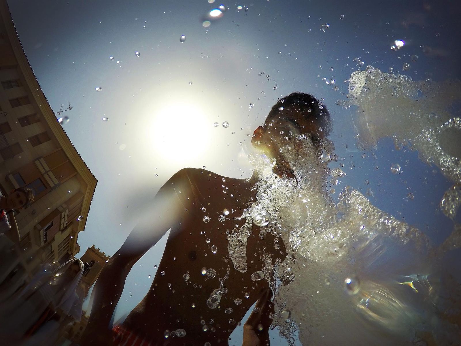 La primera ola de calor llega a España con temperaturas que rozarán los 50 grados en el sur. Normal que busquemos el agua para refrescarnos en cualquier momento. Este niño se refresca en una fuente de Alicante.