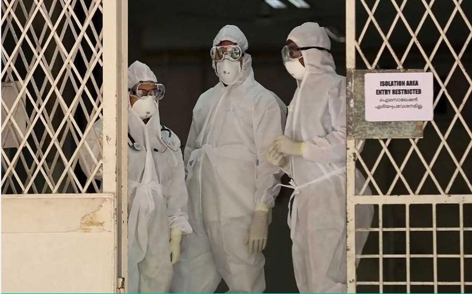 Personal médico con trajes protectores ante un hospital en cuarentena en Kochi, Kerala (India)