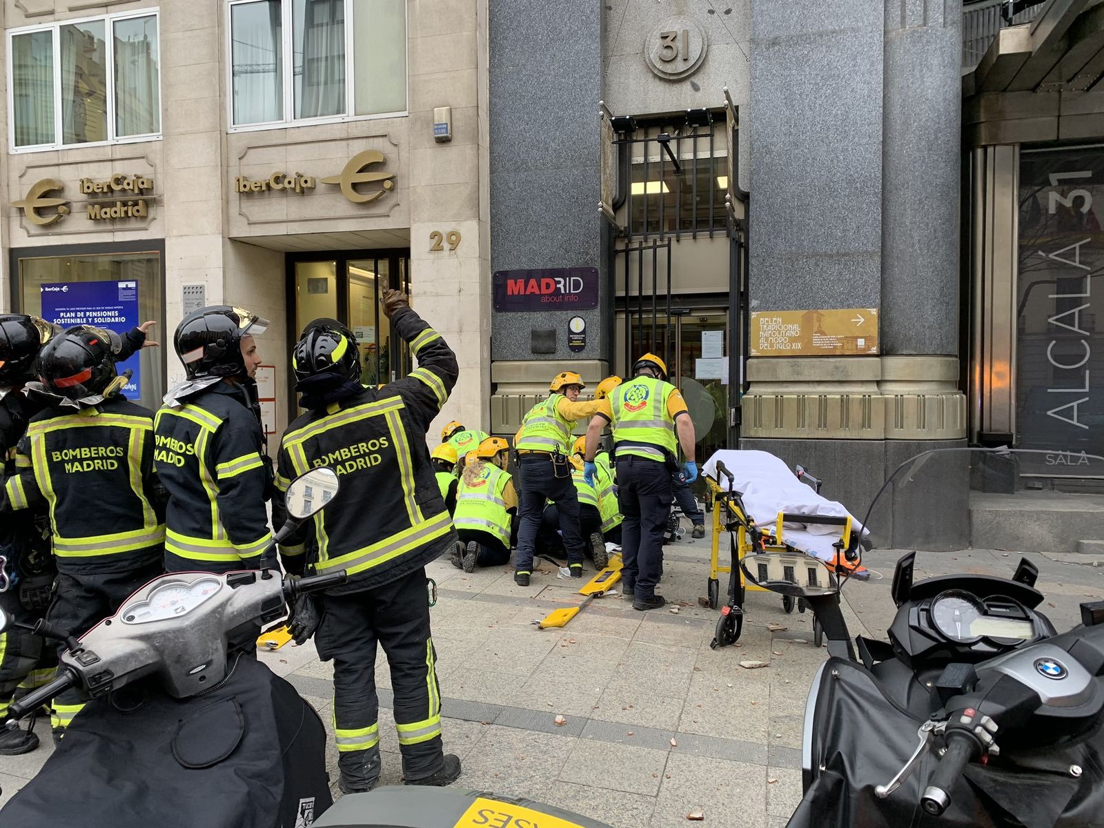Sanitarios atienden a la mujer coreana que finalmente falleció tras recibir el impacto de unos cascotes en la calle Alcalá