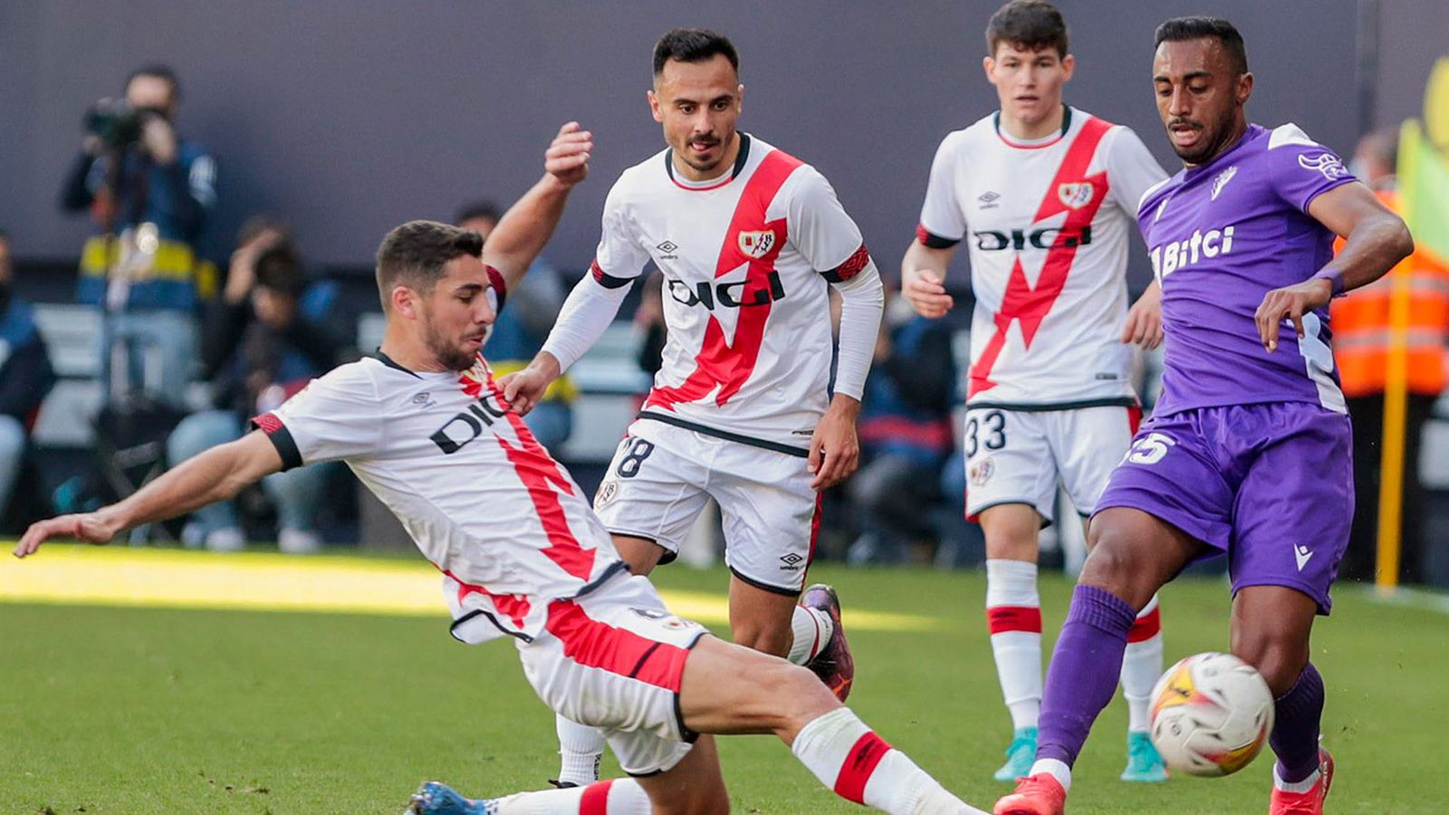 El centrocampista del Rayo Vallecano, Santi (i) lucha por el balón con el defensa del Cádiz CF, Akapo, durante el partido de Liga que enfrenta este domingo al Cádiz CF y al Rayo Vallecano en el Estadio Nuevo Mirandilla de Cádiz
