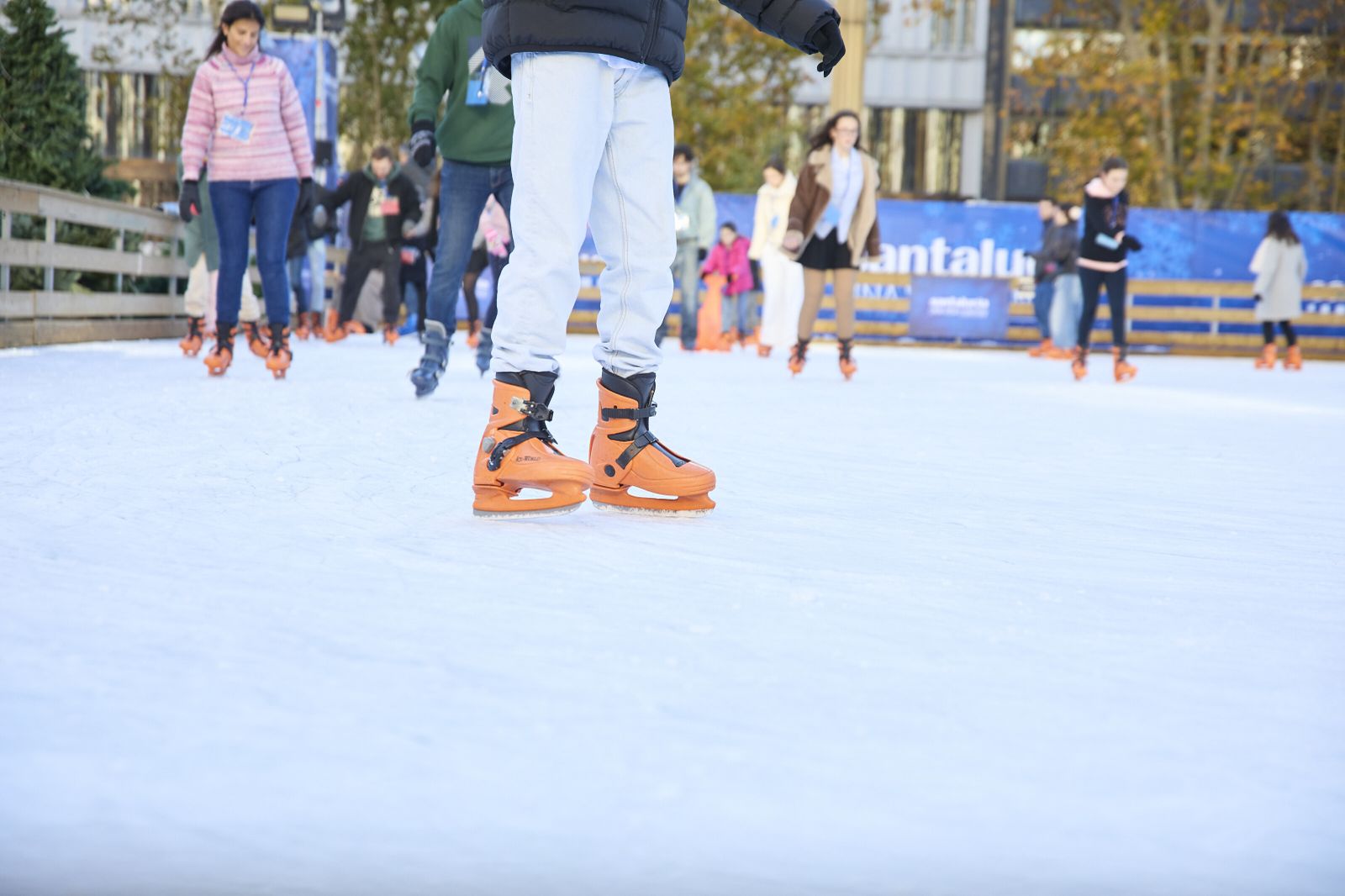 Varias personas patinan en la pista de hielo en la plaza de España