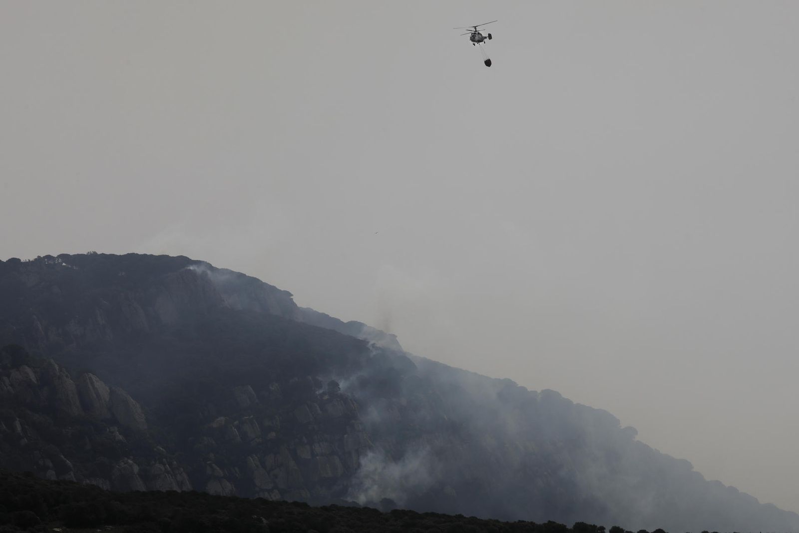 Un helicóptero lucha contra el incendio de Tarifa