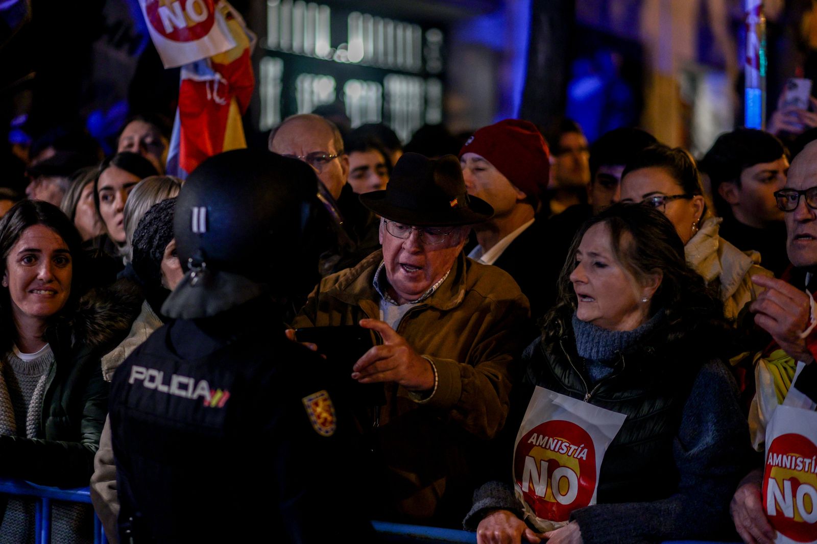 Varias personas durante una concentración en contra de la amnistía, frente a la sede del PSOE en la calle Ferraz,