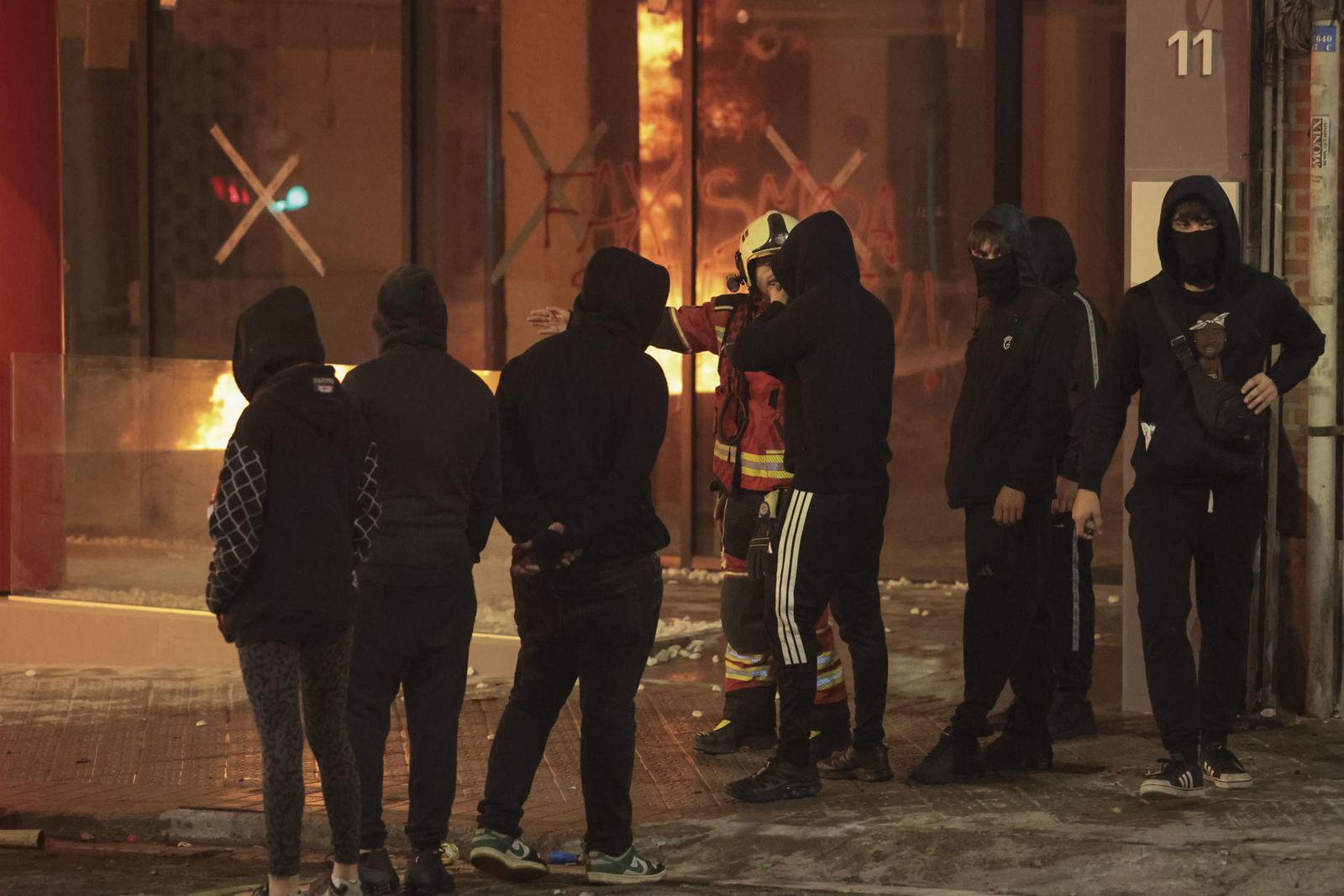 Un bombero habla con un grupo de asistentes a la manifestación de estudiantes y de colectivos 'antifascistas' este lunes por el centro de Bilbao