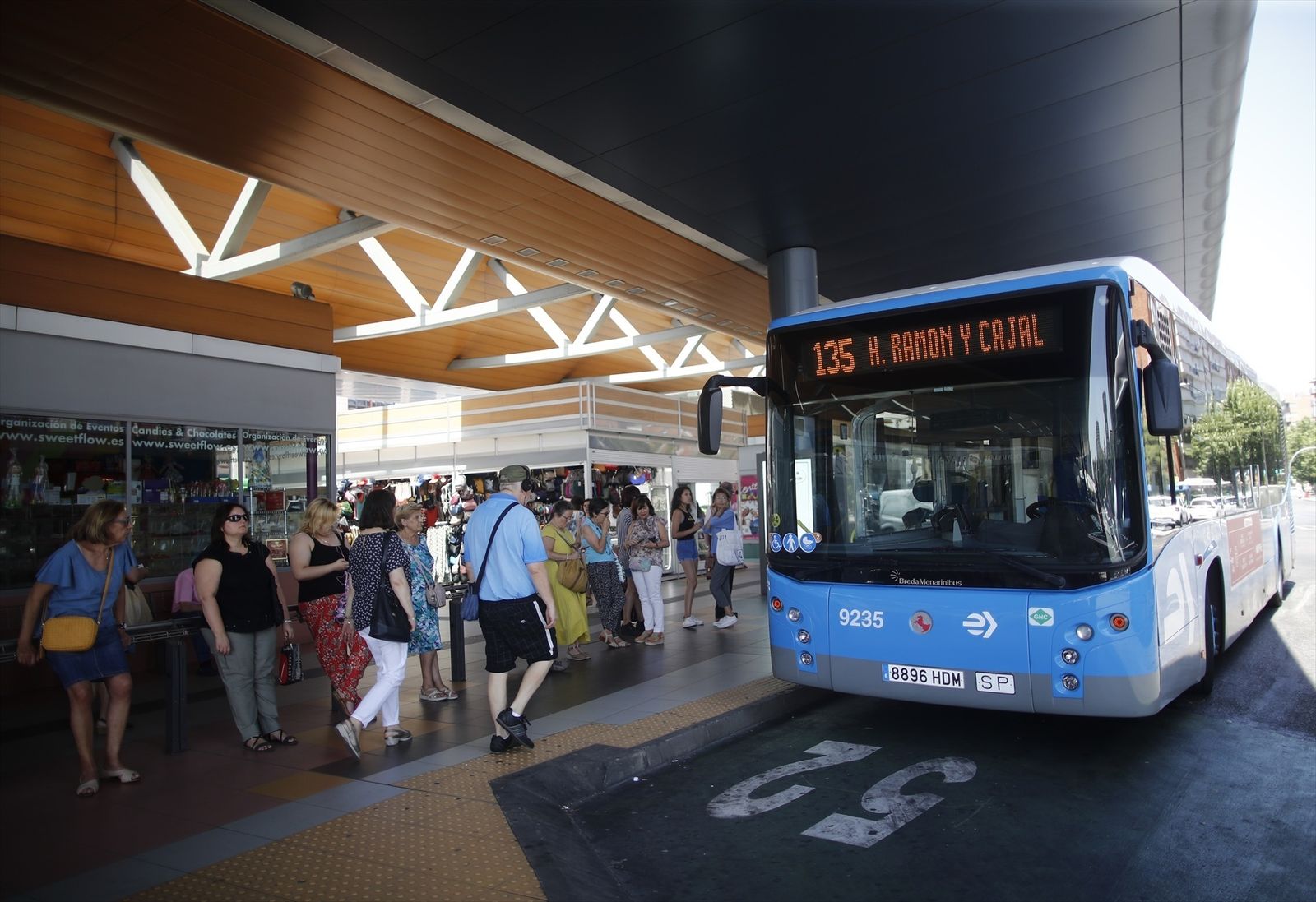 Varias personas esperan al autobús de la EMT, línea 135, en la estación de autobuses de Plaza de Castilla