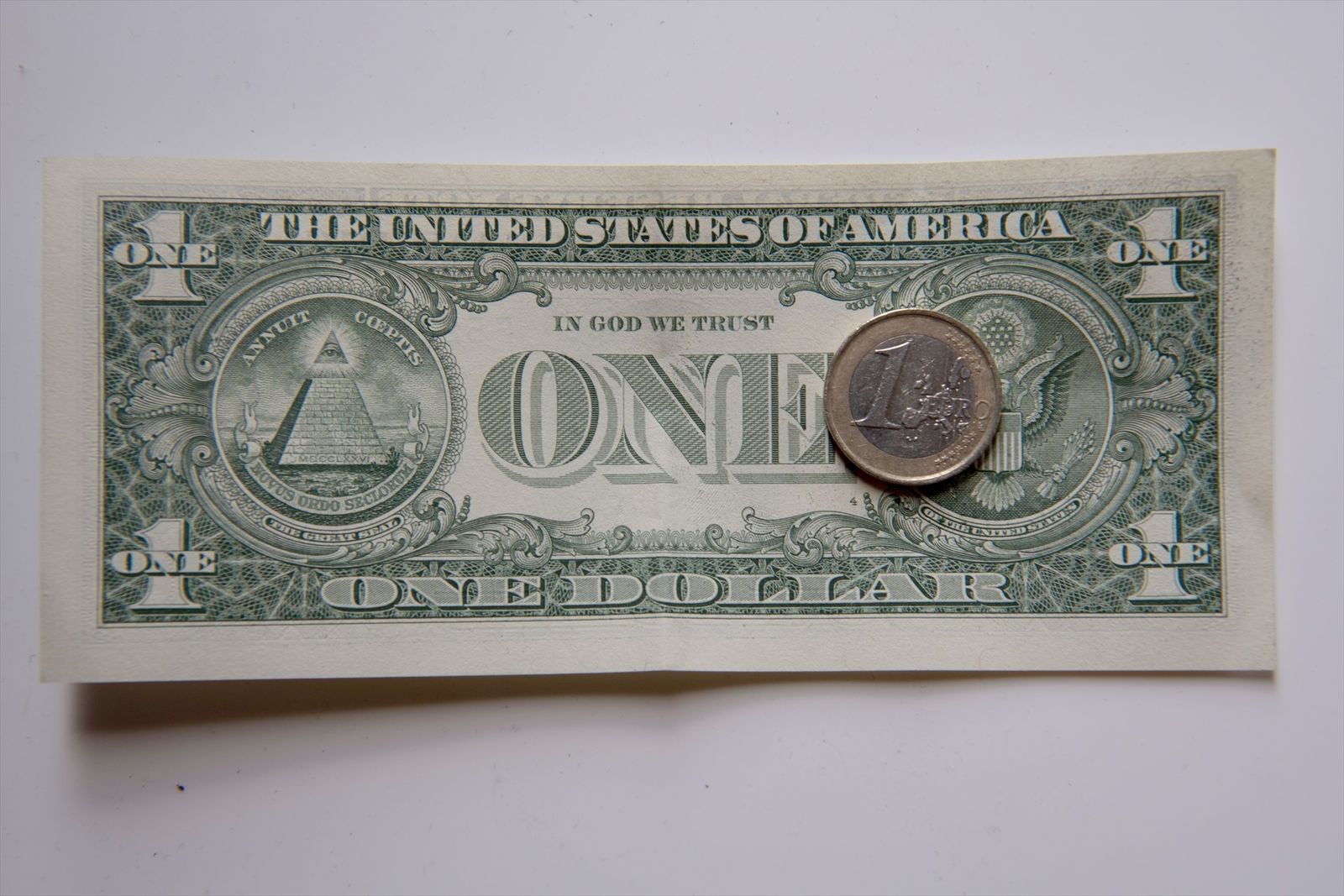 Una moneda de un euro sobre un billete de un dólar