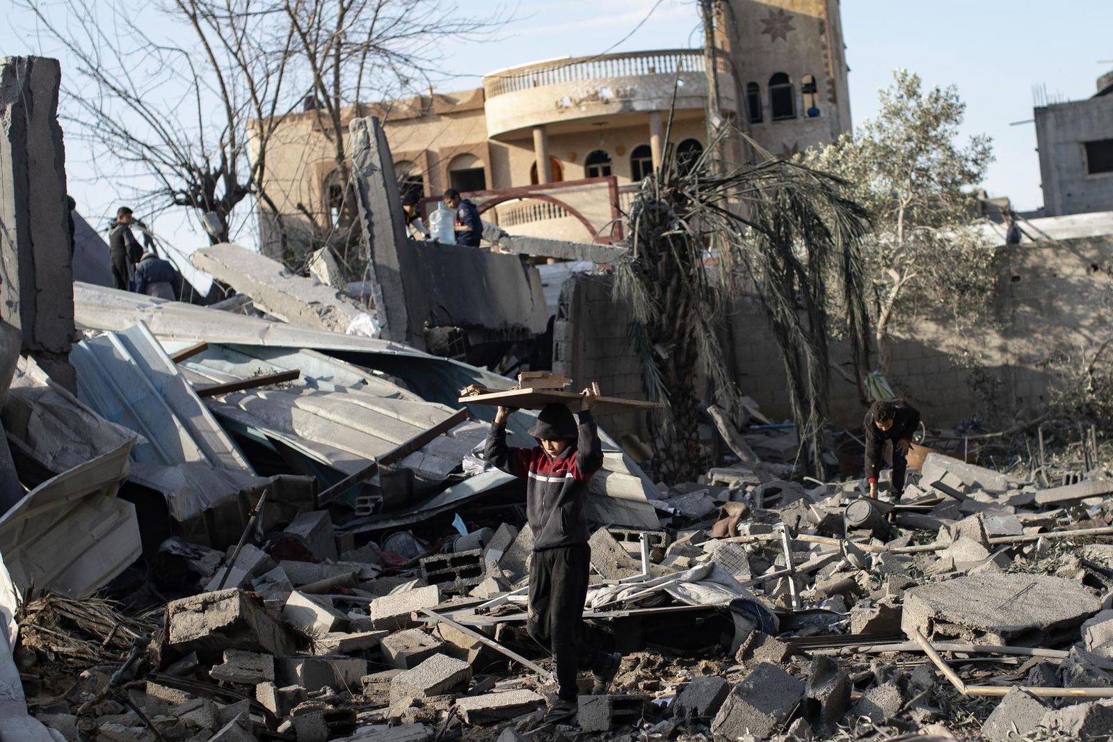 Palestinos entre escombros en la ciudad de Gaza