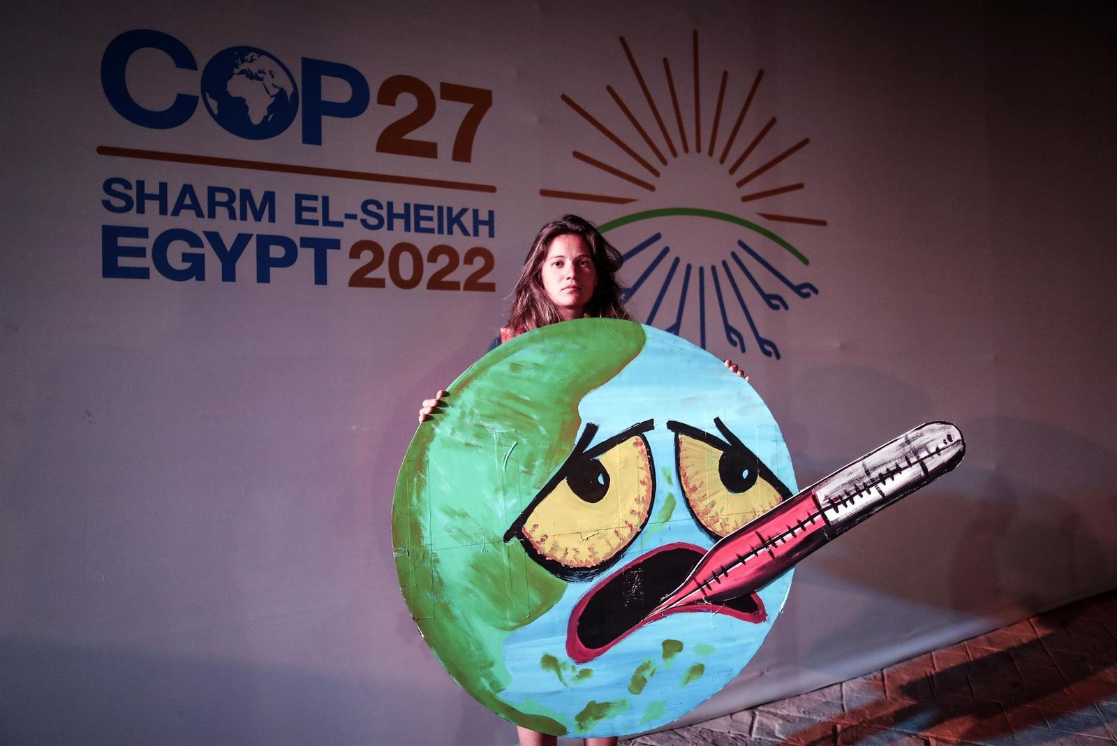 Una activista exhibe un cartel sobre el calentamiento de la Tierra en la COP27 de Egipto