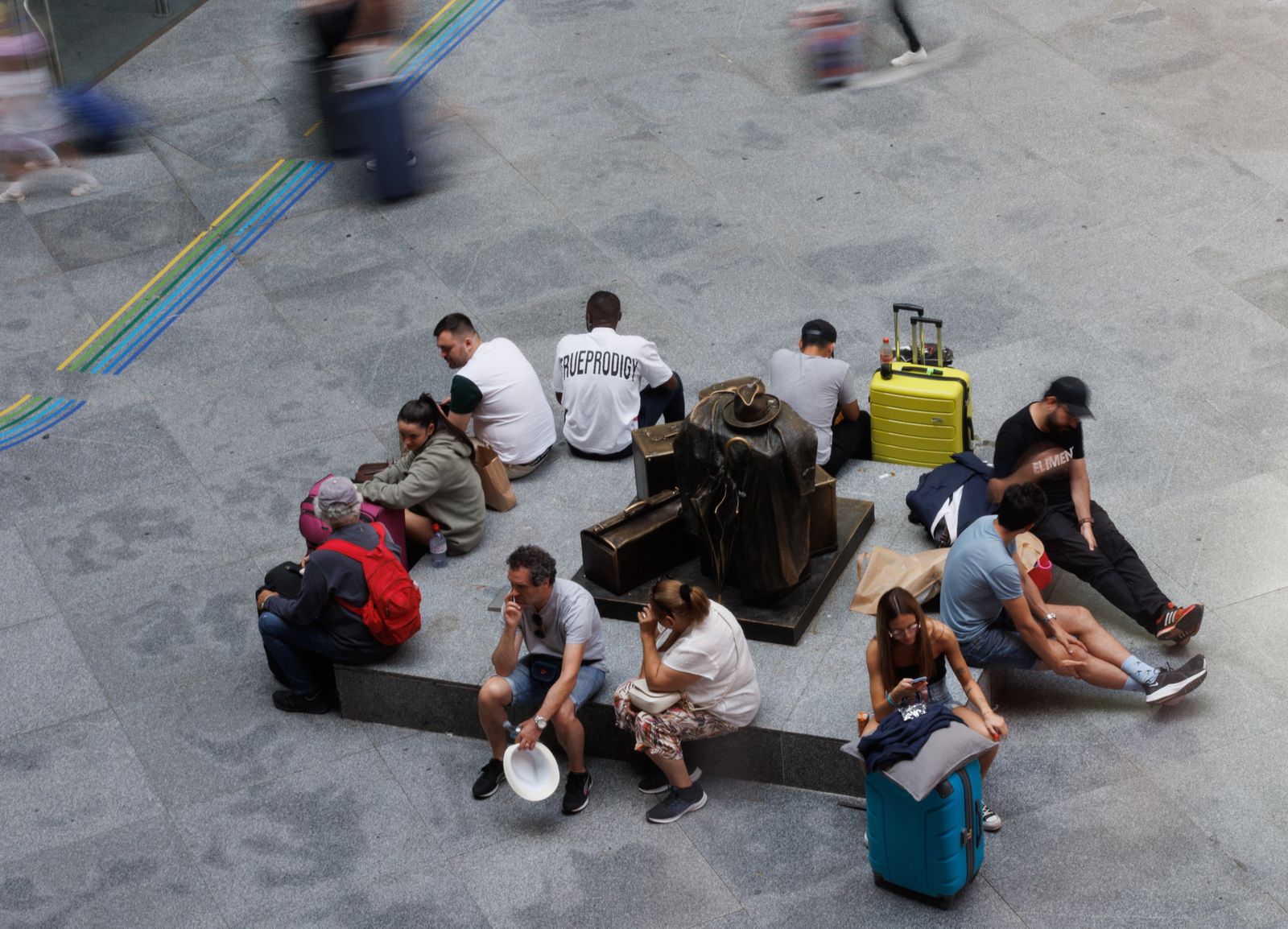 Varias personas esperan con maletas en la estación de Atocha-Almudena Grandes