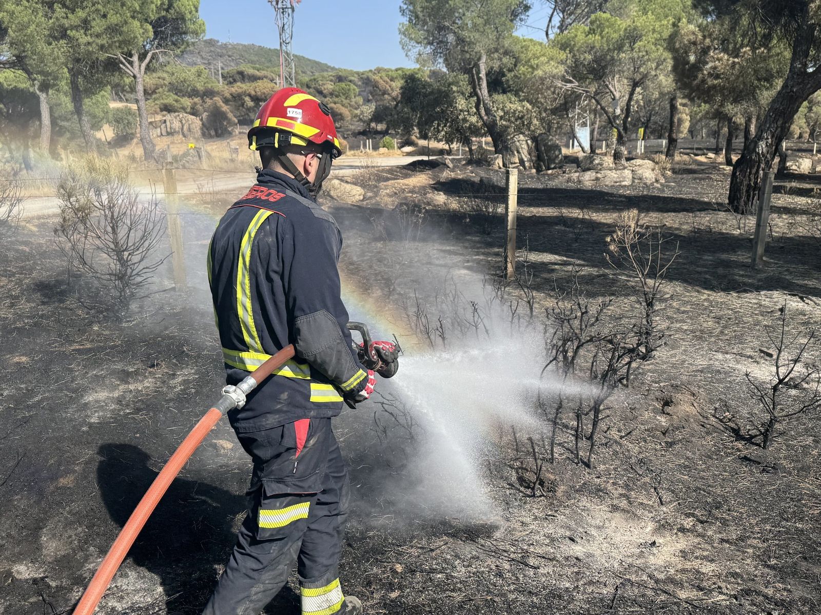 Una veintena de dotaciones mantienen sin reproducciones el incendio de la sierra madrileña durante la noche
