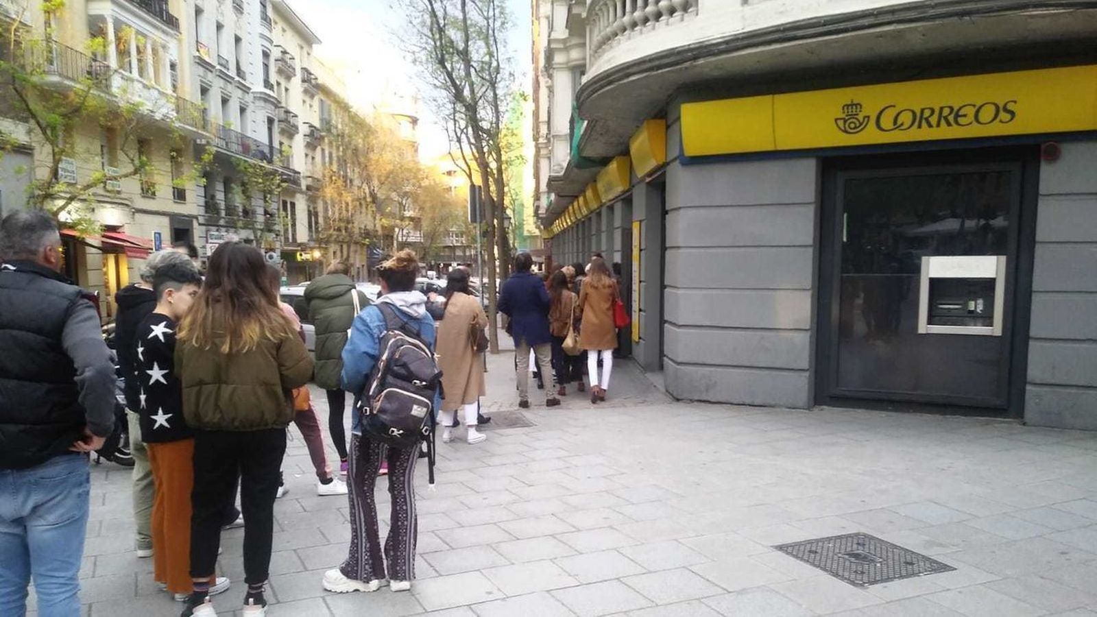 Personas hacen cola frente a una oficina de Correos