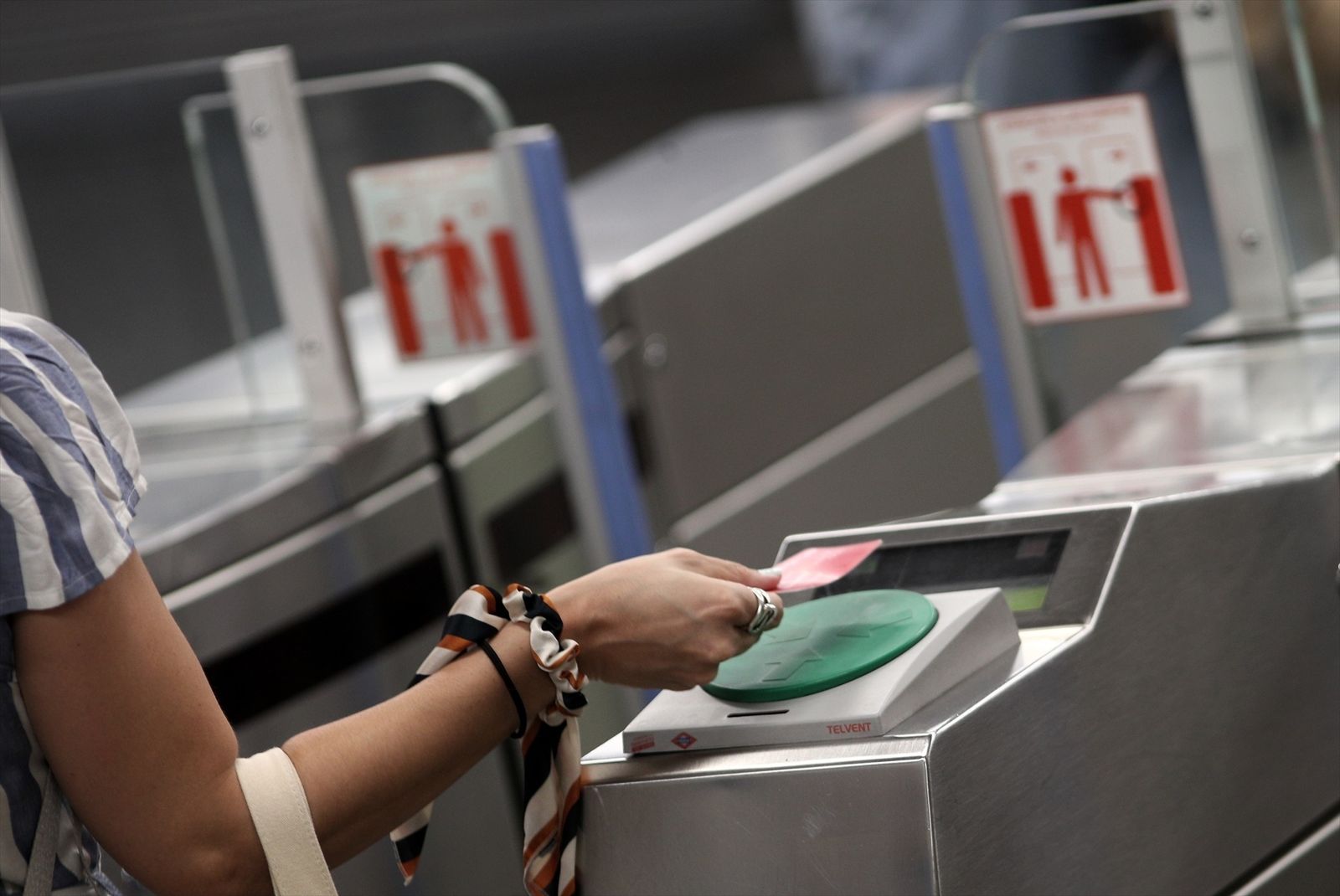 Una mujer pasa la tarjeta transporte en el Metro de Madrid