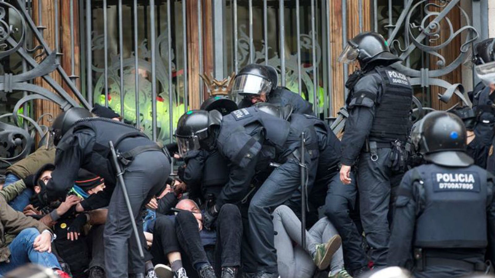 Agentes de los Mossos d'Esquadra desalojan a las decenas de personas se han concentrado a primera hora de esta mañana ante el