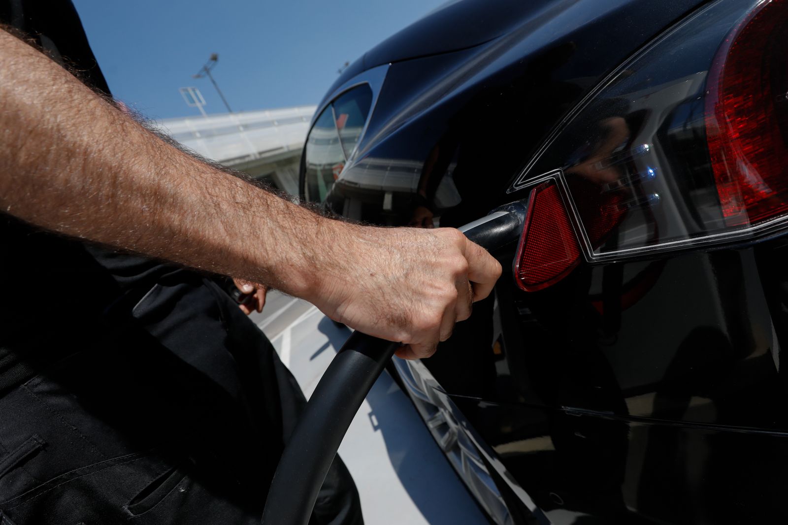 Una persona recarga su vehículo eléctrico en un punto de recarga