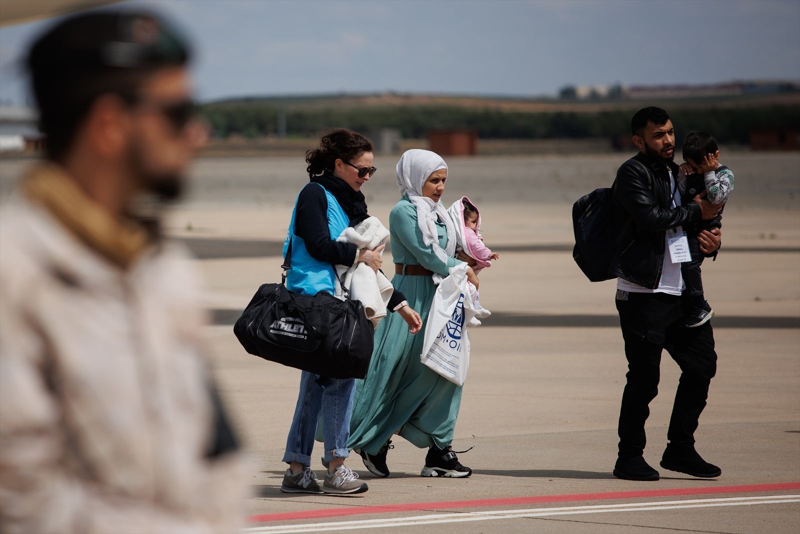 Una familia con dos niños procedentes de Siria a su llegada a la base aérea de Torrejón de Ardoz