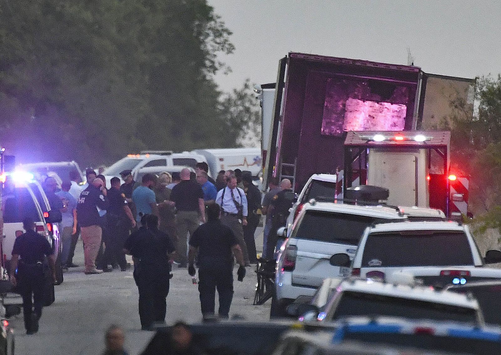 Personal de emergencias investiga la escena donde se encontró el camión con los migrantes muertos