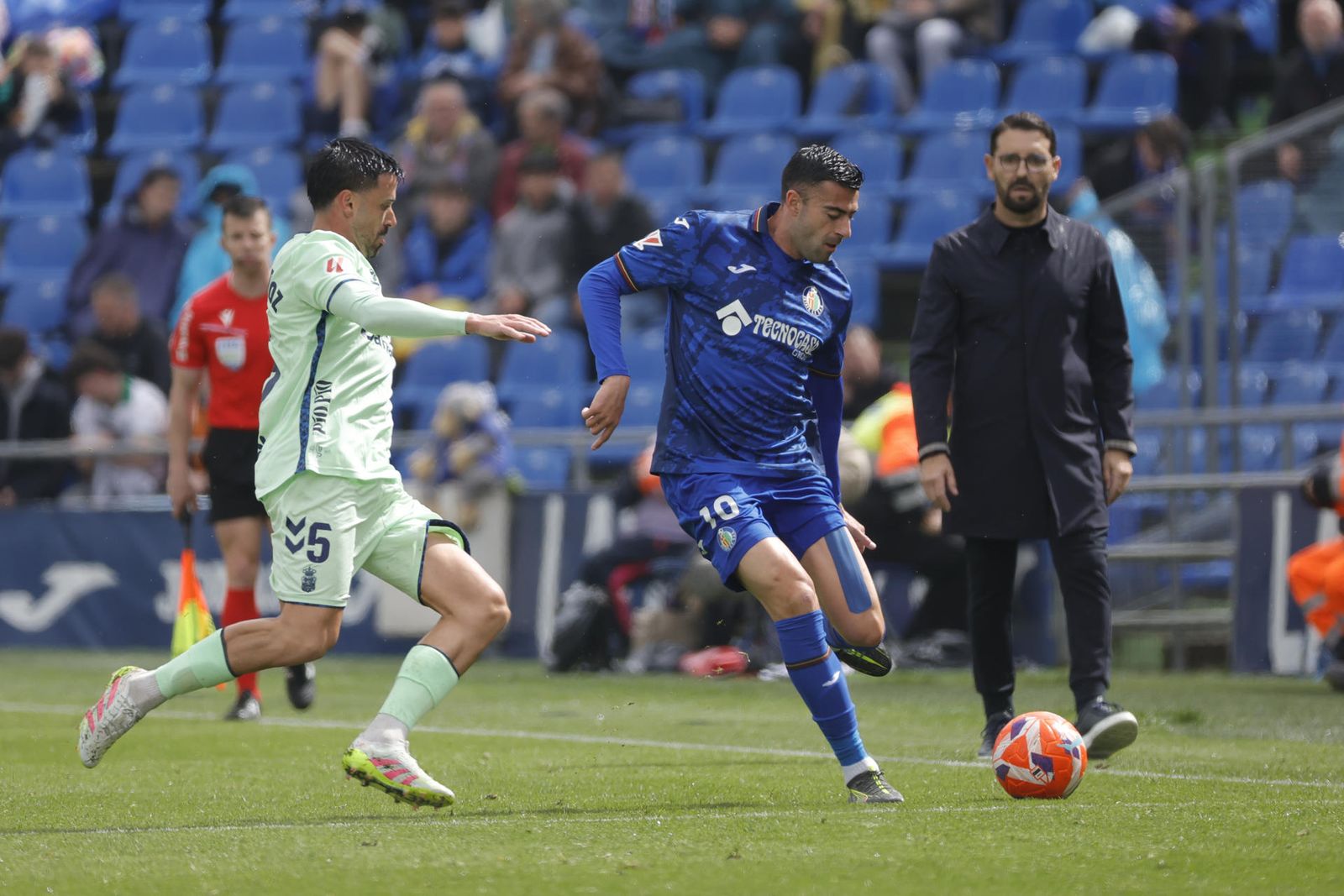 El defensa del Getafe Diego Rico disputa un balón con el centrocampista de Las Palmas Javi Muñoz