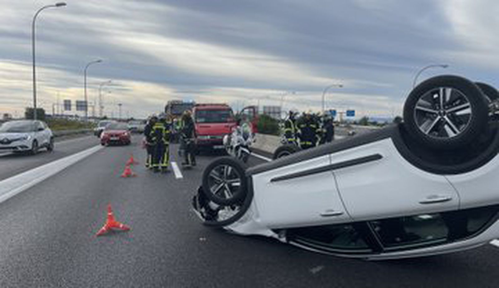 Turismo volcado en el puente que une la M-607 con la M-40 en Madrid