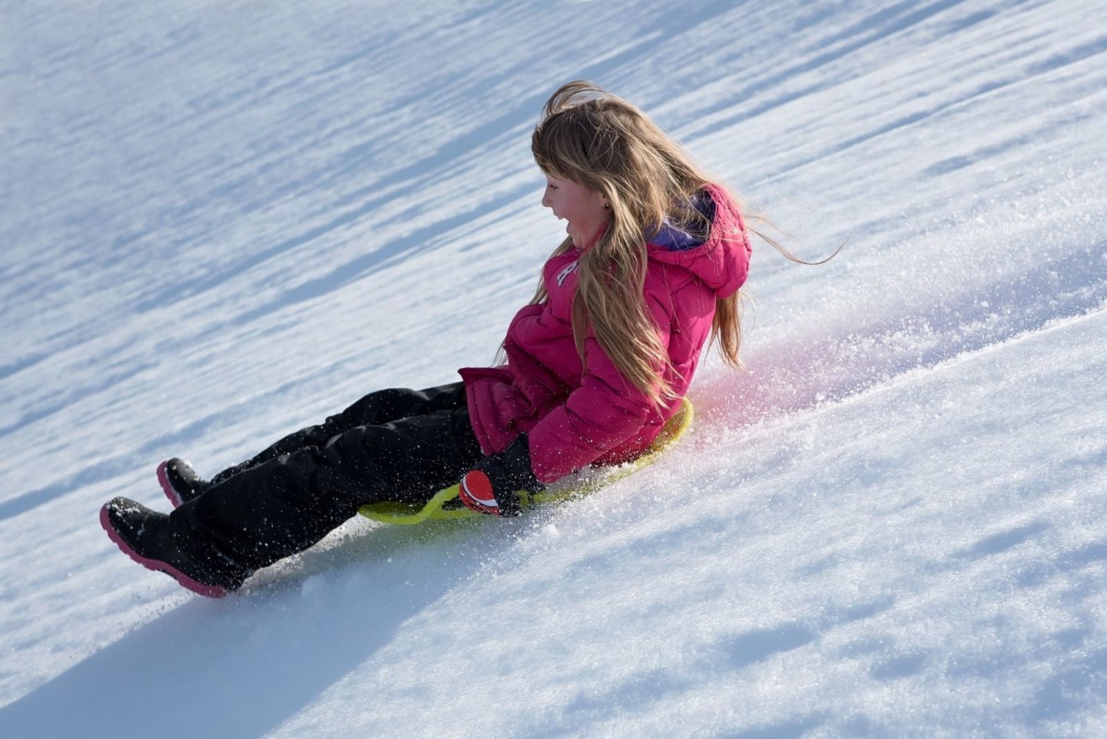 Una chica deslizándose por una pista de nieve