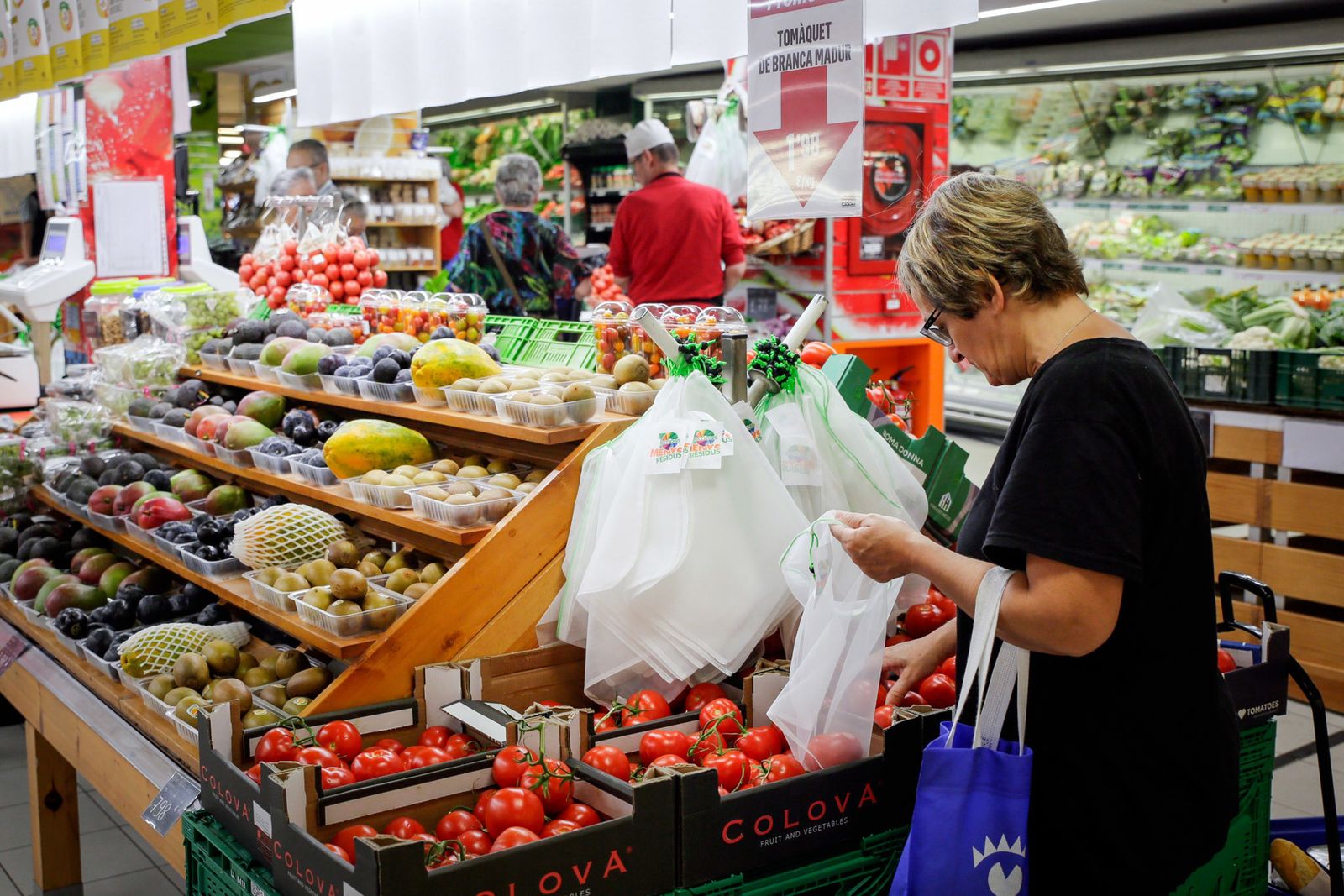 Una mujer hace la compra en la sección de frutería de un supermercado