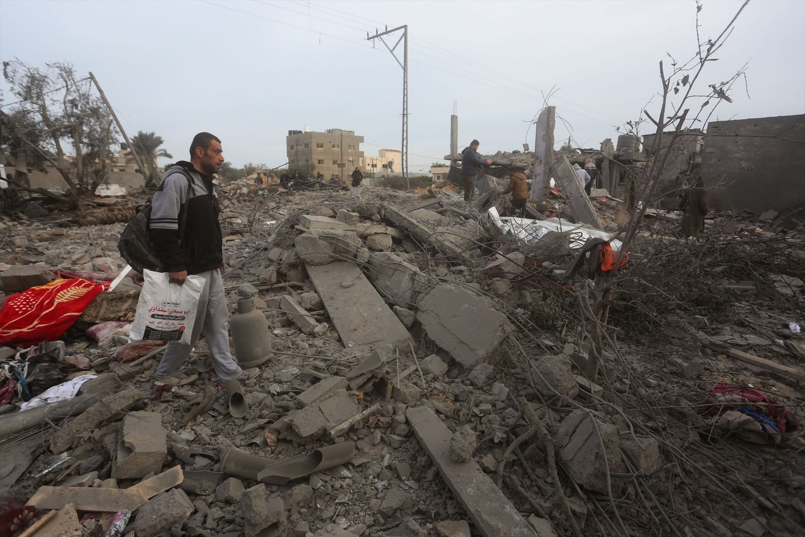 Varios palestinos entre los escombros de un edificio destruido por los ataques del Ejército de Israel