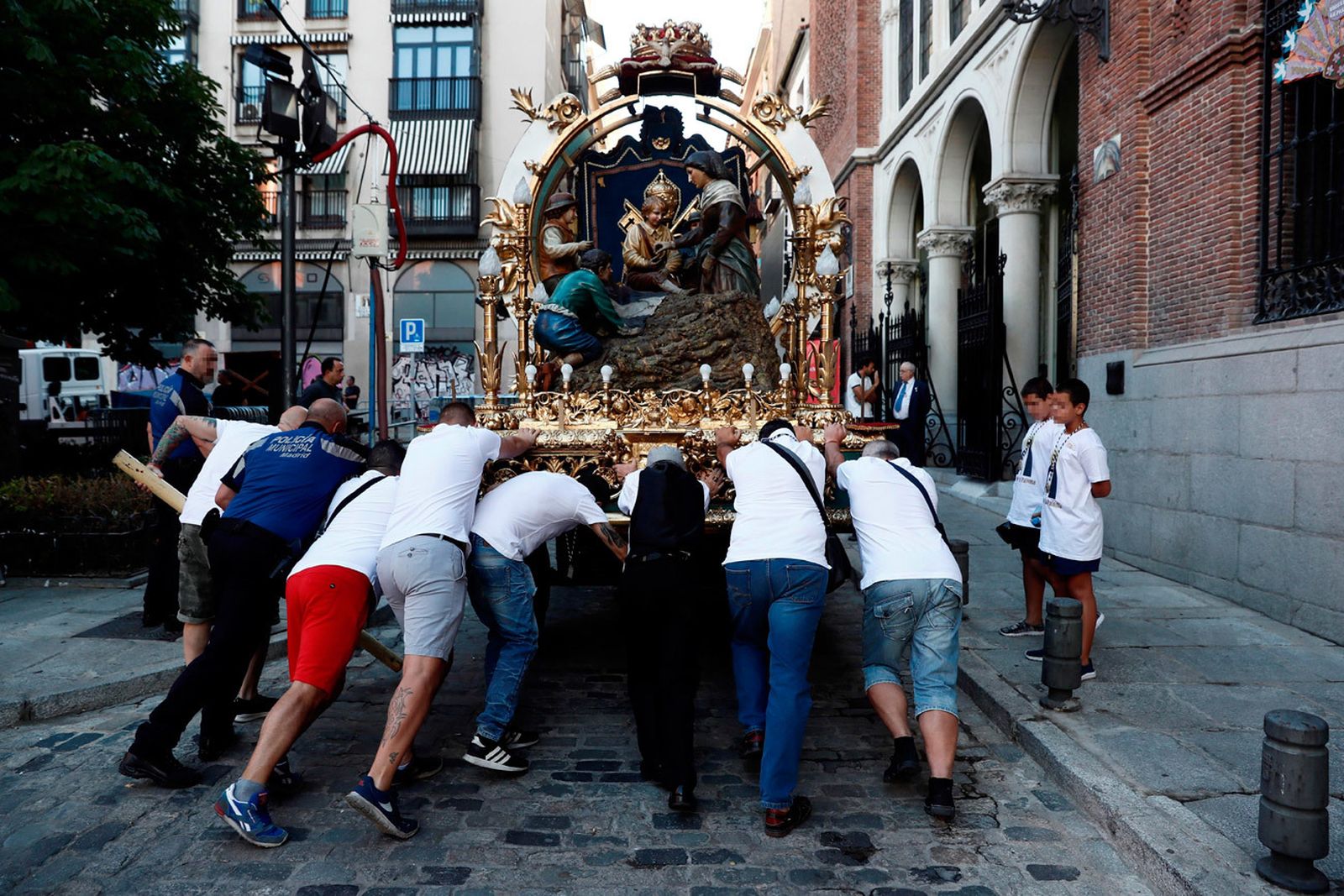 omberos y fieles de la congregación trabajan en los preparativos de la carroza para la procesión de la Virgen de La Paloma