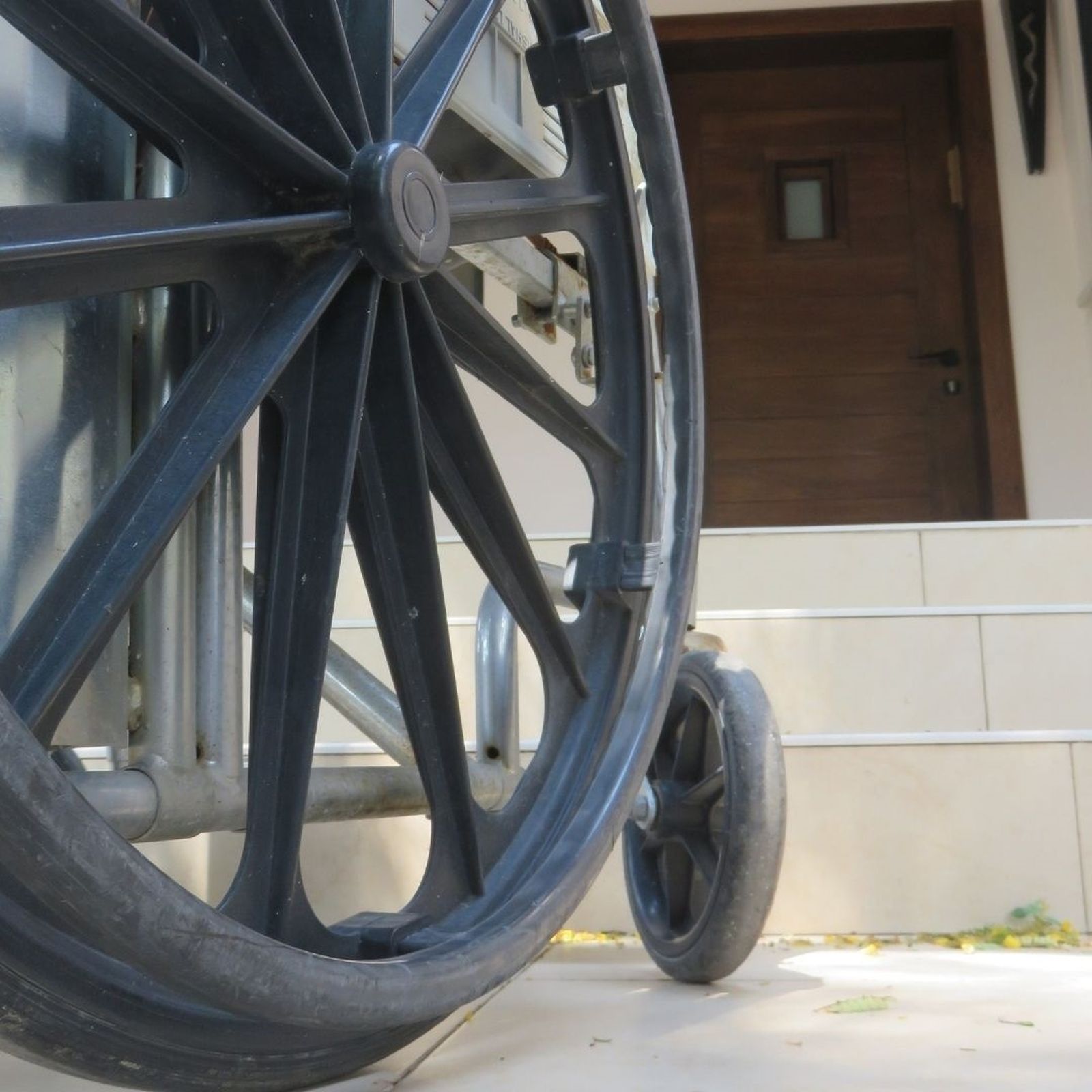 Silla de ruedas frente a un edificio con escaleras en su entrada
