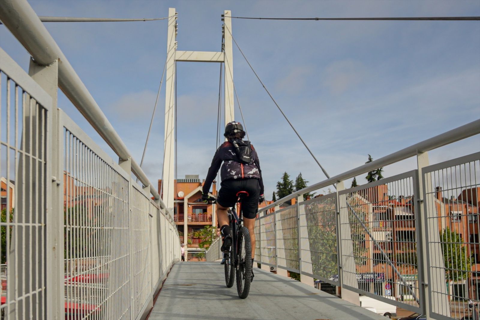 Un hombre circula en bicicleta por una pasarela en Madrid